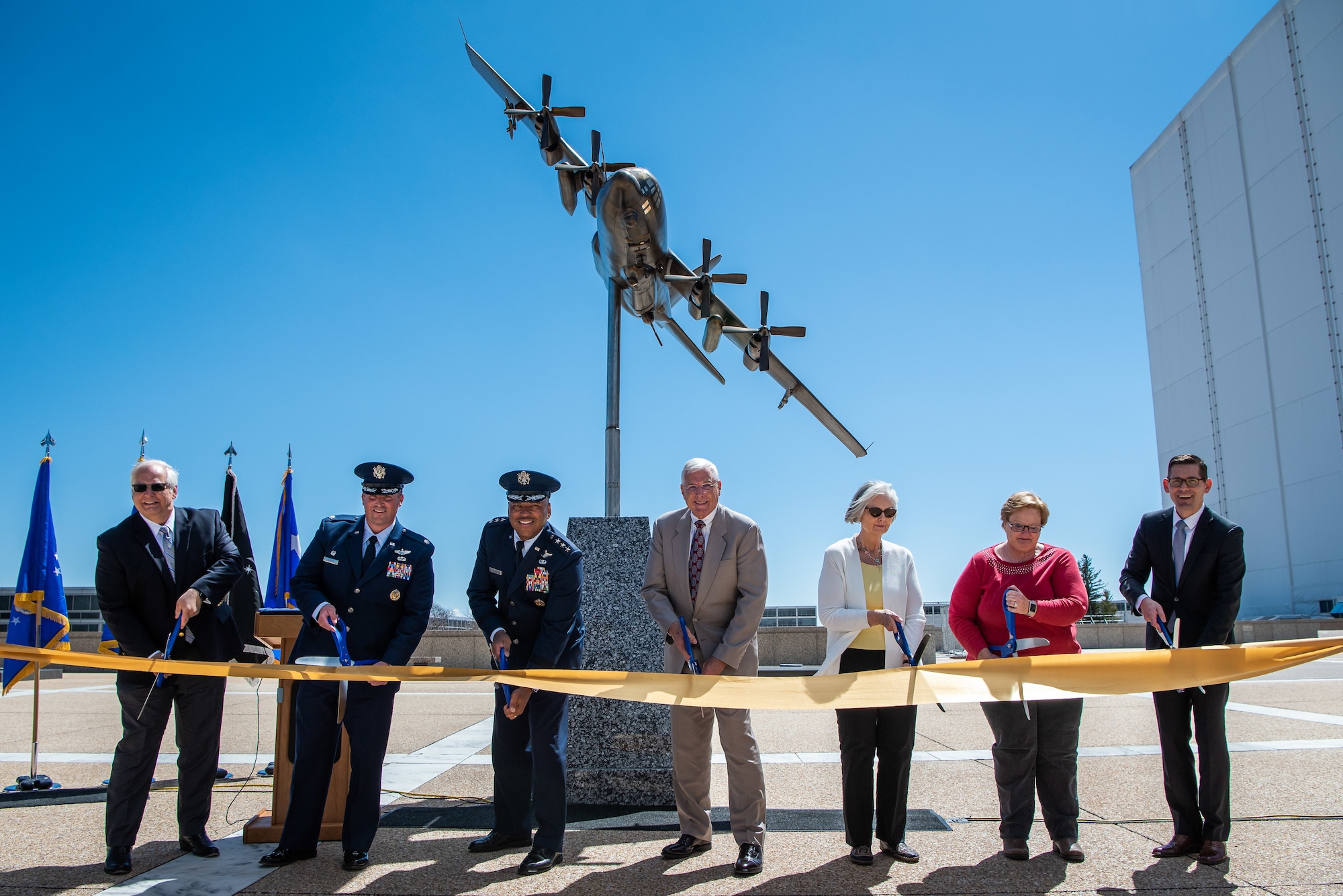 A group of representatives from the U.S. Air Force Academy, City of Colorado Springs, Academy Foundation and Associate of Graduates and Major Paul Weaver's family cut a ribbon to dedicate an AC-130H Sprectre gunship sculpture during a ceremony at the Air Force Academy Colorado on May 5, 2023.