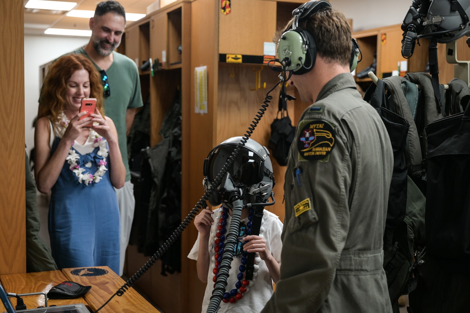 First Lt. Benjamin Peila, 199th Fighter Squadron F-22 Raptor pilot, tests the communication system inside of a pilot’s helmet with Elliott from the Make-A-Wish Foundation of Greater Los Angeles at Joint Base Pearl Harbor-Hickam, Hawaii, May 5, 2023. Peila led Elliot through a tour of the fighter squadron’s headquarters, highlighting the pilot’s gear and the F-22. (U.S. Air Force photo by Staff Sgt. Alan Ricker)