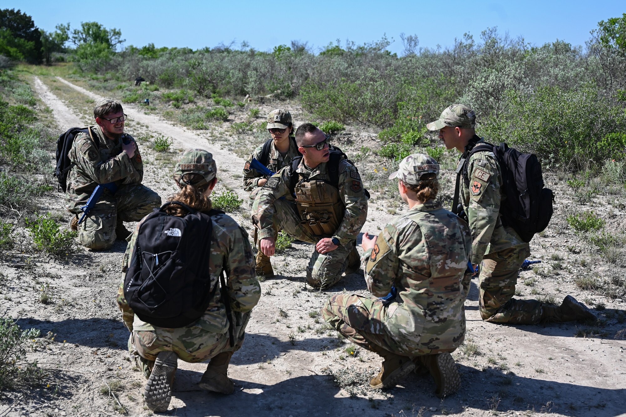 U.S. Air Force Master Sgt. Mike Alberti (center), 47th Security Forces Squadron superintendent of plans and programs, kneels in the middle of five fireteam leaders during a training exercise at Laughlin Air Force Base, Texas, on April 28, 2023.