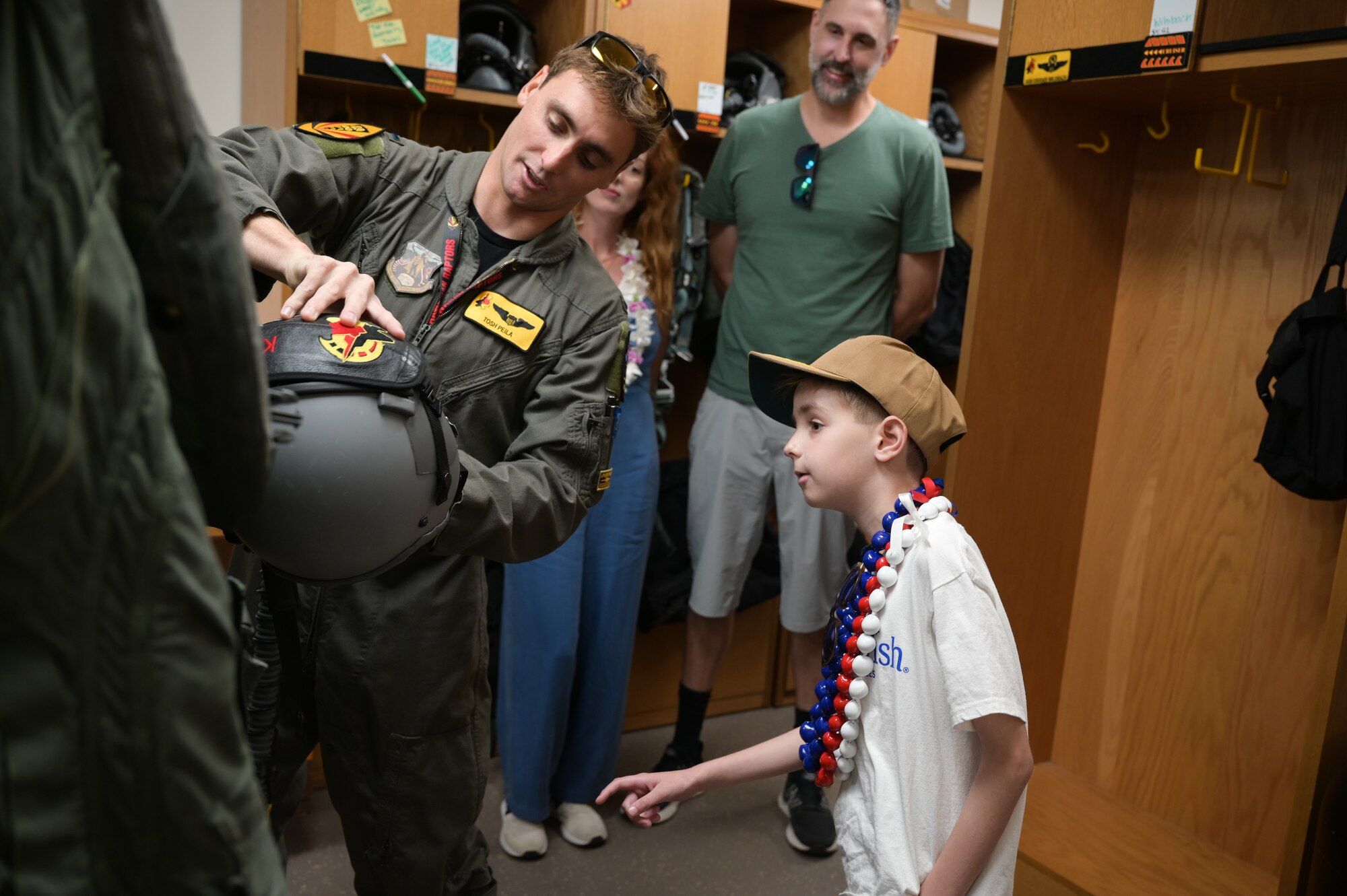 First Lt. Benjamin Peila, 199th Fighter Squadron F-22 Raptor pilot, shows the communication system inside of a pilot’s helmet to Elliott from the Make-A-Wish Foundation of Greater Los Angeles at Joint Base Pearl Harbor-Hickam, Hawaii, May 5, 2023. The 15th Wing and the 154th Wing hosted Elliott, showcasing the 19th and 199th Fighter Squadrons and the F-22. (U.S. Air Force photo by Staff Sgt. Alan Ricker)