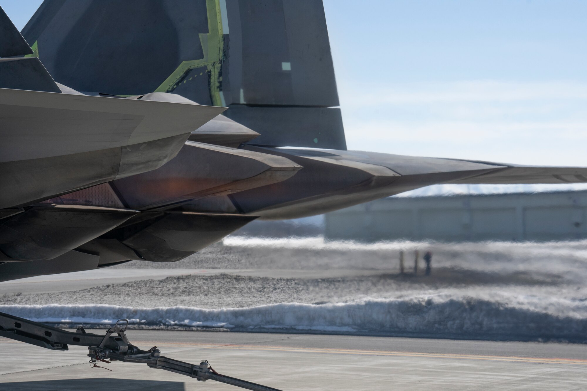 The translucent flames from the exhaust of an F-22 Raptor fighter jet distort the air behind the jet