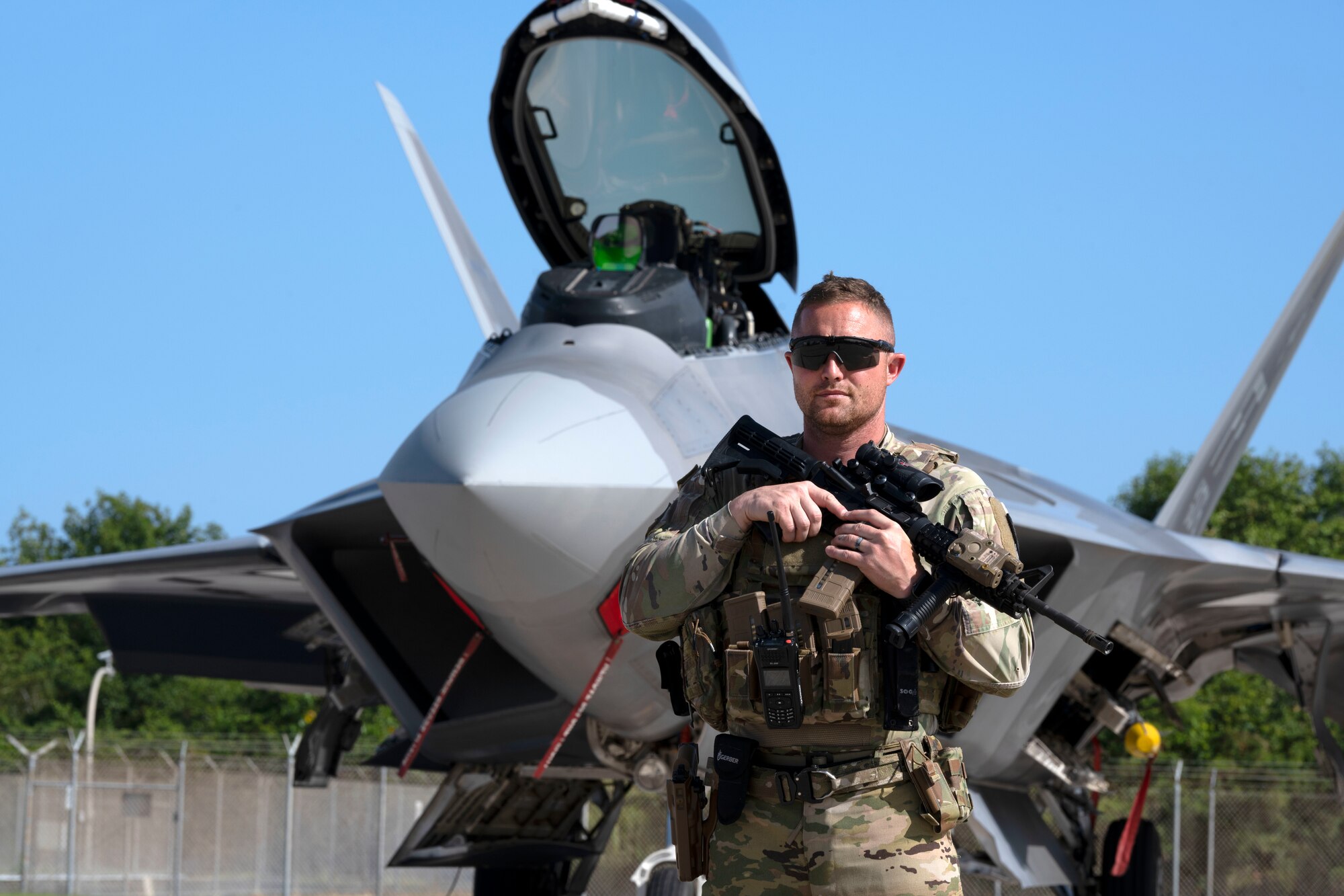 U.S. Air Force Master Sgt. Nicholas Collins, a raven team member assigned to the 121st Security Forces Squadron, guards an F-22 Raptor assigned to the 192nd Wing, Virginia Air National Guard, during Operation Hoodoo Sea at Muñiz Air National Guard Base, Carolina, Puerto Rico, May 4, 2023. Operation Hoodoo Sea is a multi-unit training exercise where participant units conduct agile combat training in the coastal southeast of the U.S. to test agile communications innovations, portable aerospace ground equipment, aircraft concealment hangars and survival kits. (U.S. Air National Guard photo by Master Sgt. Rafael Rosa)