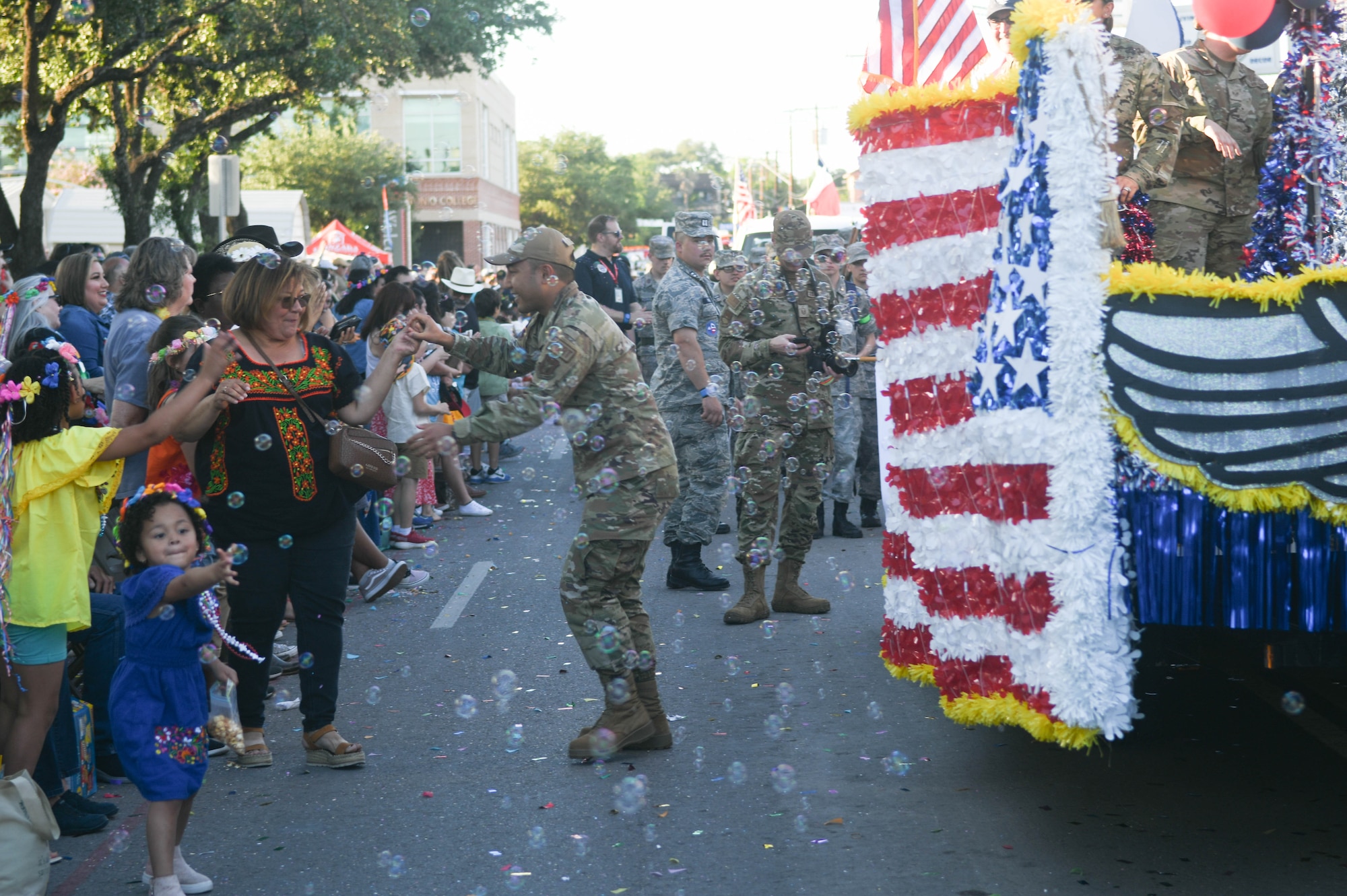 U.S. Air Force Senior Airman Jahred Reyes, 74th Aerial Port Squadron air transportation specialist, dances with a spectator at the 2023 Fiesta Flambeau Parade in San Antonio, Texas, April 29, 2023. Over 750,000 spectators were in attendance during the parade. (U.S. Air Force photo by Senior Airman Brittany Wich)