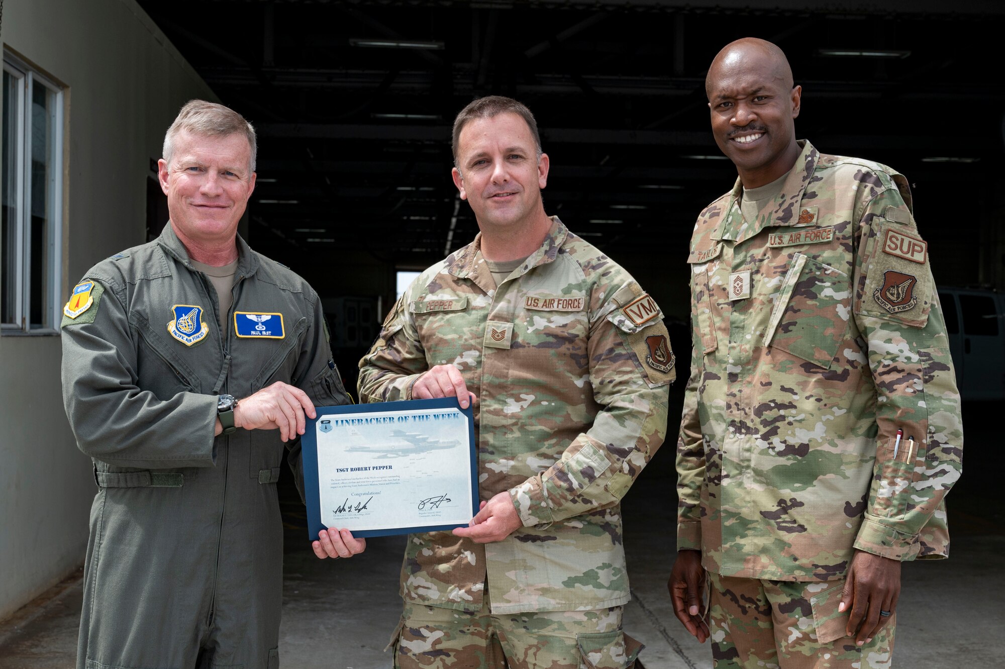 U.S. Air Force Tech. Sgt. Robert Pepper, the noncommissioned officer in charge of Silver Flag maintenance assigned to the 36th Logistics Readiness Squadron, receives the Linebacker of the Week Award from U.S. Air Force Brig. Gen. Paul Fast, commander of the 36th Wing, and U.S. Air Force Chief Master Sgt. Nicholas Taylor, the command chief of the 36th Wing, at Andersen Air Force Base, Guam, April 19, 2023. The Team Andersen Linebacker of the Week recognizes outstanding enlisted, officer, civilian and total force personnel who have had an impact on achieving Team Andersen’s mission, vision and priorities. (U.S. Air Force photo by Airman 1st Class Emily Saxton)