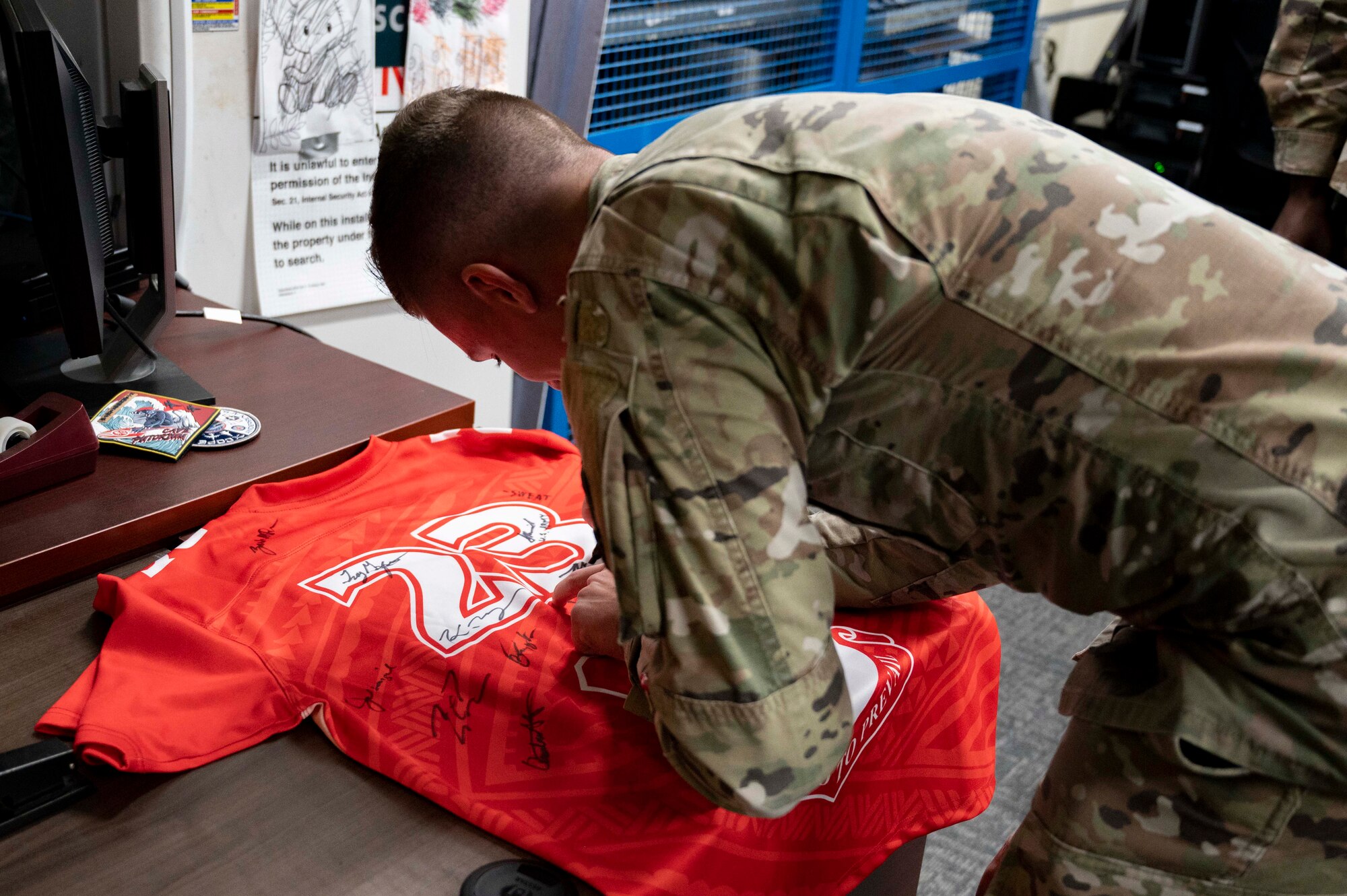 U.S. Air Force Senior Airman Tanner Geil, a radio transmissions system operations technician assigned to the 36th Communications Squadron, signs the Linebacker of the Week jersey at Andersen Air Force Base, Guam, April 5, 2023. The Team Andersen Linebacker of the Week recognizes outstanding enlisted, officer, civilian and total force personnel who have had an impact on achieving Team Andersen’s mission, vision and priorities. (U.S. Air Force photo by Airman 1st Class Emily Saxton)