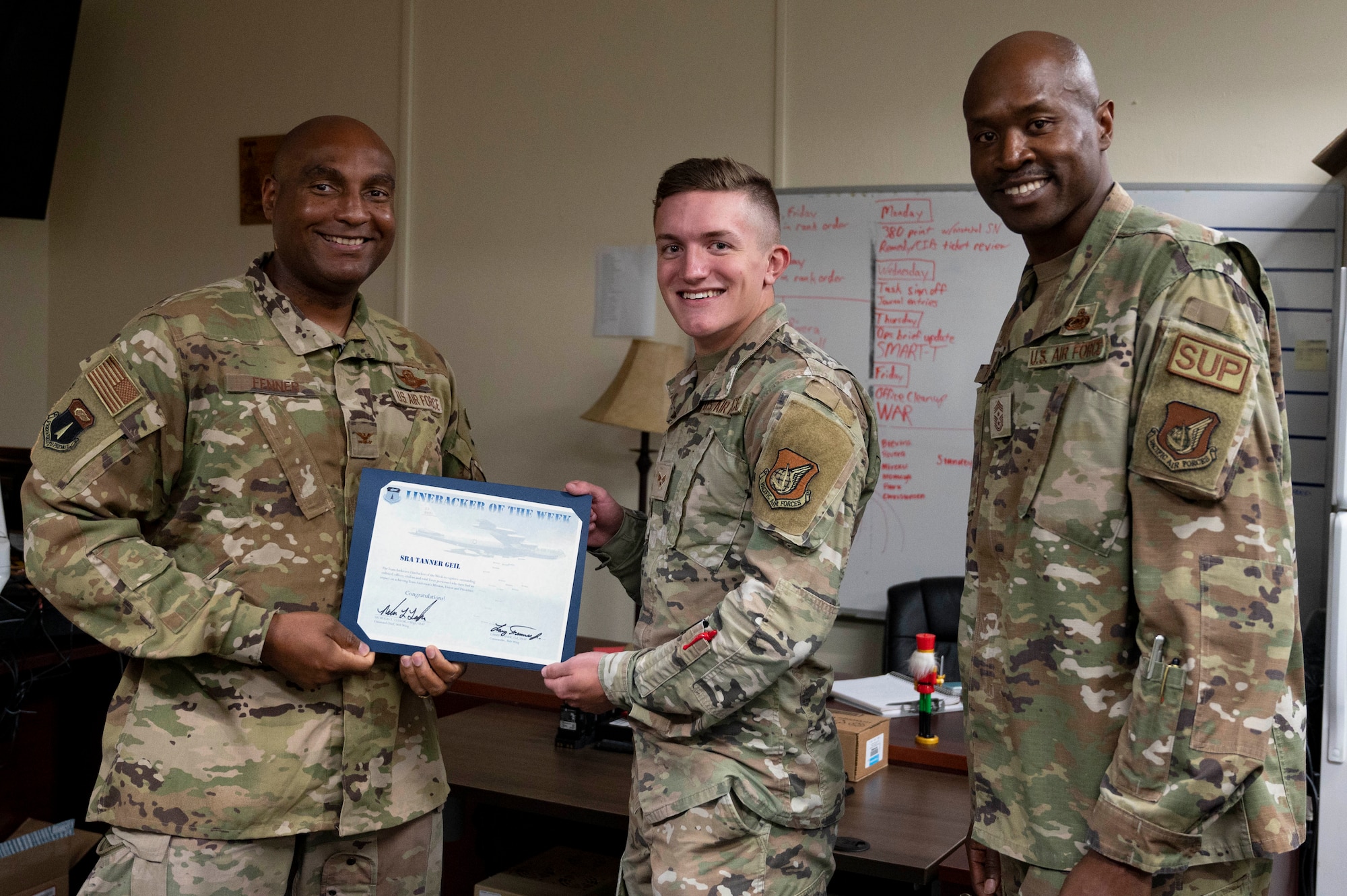 U.S. Air Force Senior Airman Tanner Geil, a radio transmissions system operations technician assigned to the 36th Communications Squadron, receives the Linebacker of the Week Award from U.S. Air Force Col. Larry Fenner, vice commander of the 36th Wing, and U.S. Air Force Chief Master Sgt. Nicholas Taylor, the command chief of the 36th Wing, at Andersen Air Force Base, Guam, April 5, 2023. The Team Andersen Linebacker of the Week recognizes outstanding enlisted, officer, civilian and total force personnel who have had an impact on achieving Team Andersen’s mission, vision and priorities. (U.S. Air Force photo by Airman 1st Class Emily Saxton)