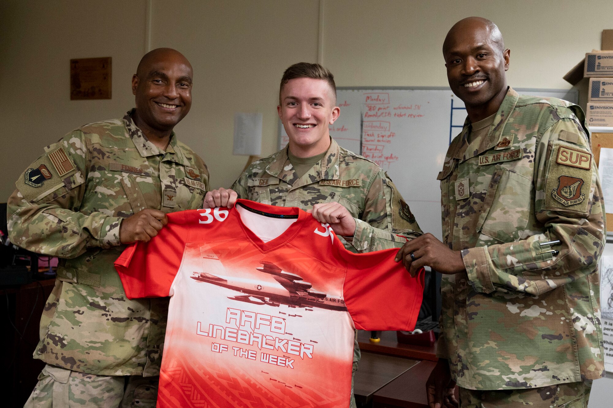 U.S. Air Force Senior Airman Tanner Geil, a radio transmissions system operations technician assigned to the 36th Communications Squadron, receives the Linebacker of the Week Award from U.S. Air Force Col. Larry Fenner, vice commander of the 36th Wing and U.S. Air Force Chief Master Sgt. Nicholas Taylor, the command chief of the 36th Wing, at Andersen Air Force Base, Guam, April 5, 2023. The Team Andersen Linebacker of the Week recognizes outstanding enlisted, officer, civilian and total force personnel who have had an impact on achieving Team Andersen’s mission, vision and priorities. (U.S. Air Force photo by Airman 1st Class Emily Saxton)