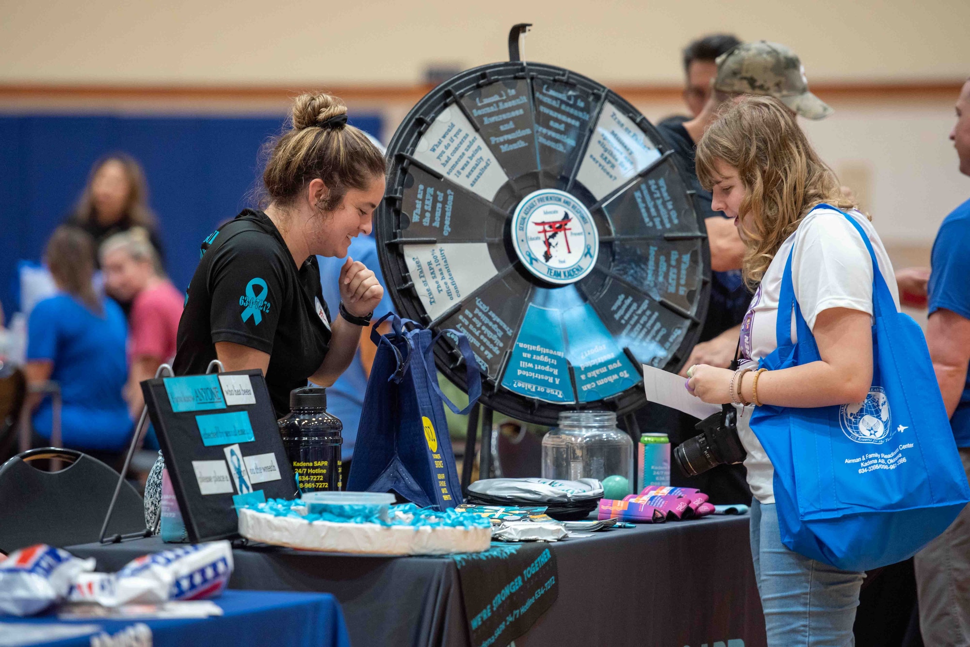 A helping agency representative speaks to an event participant