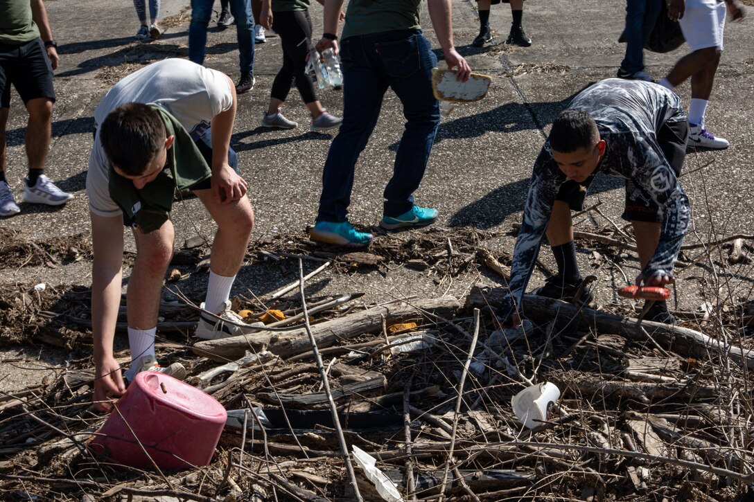 U.S. Marine Corps Cpl. Preston Joines, an Intelligence, Surveillance, and Reconnaissance system engineer, and Lance Cpl. Andres Castillo, an administrative specialist, both with Marine Forces Reserve, pick up trash during a levee clean-up in New Orleans, April 27, 2023. Marines who volunteered cleaned up half of a mile of the Algiers levee system, tightening the bond between the Marines and their local community. (U.S. Marine Corps photo by Pfc. Nicholas Bryan)