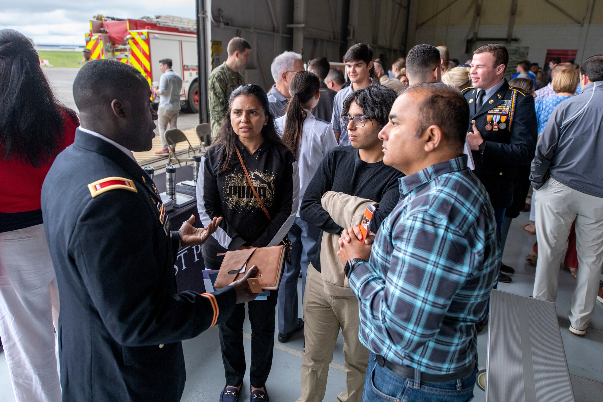 a man in an army uniform speaks to a group of students