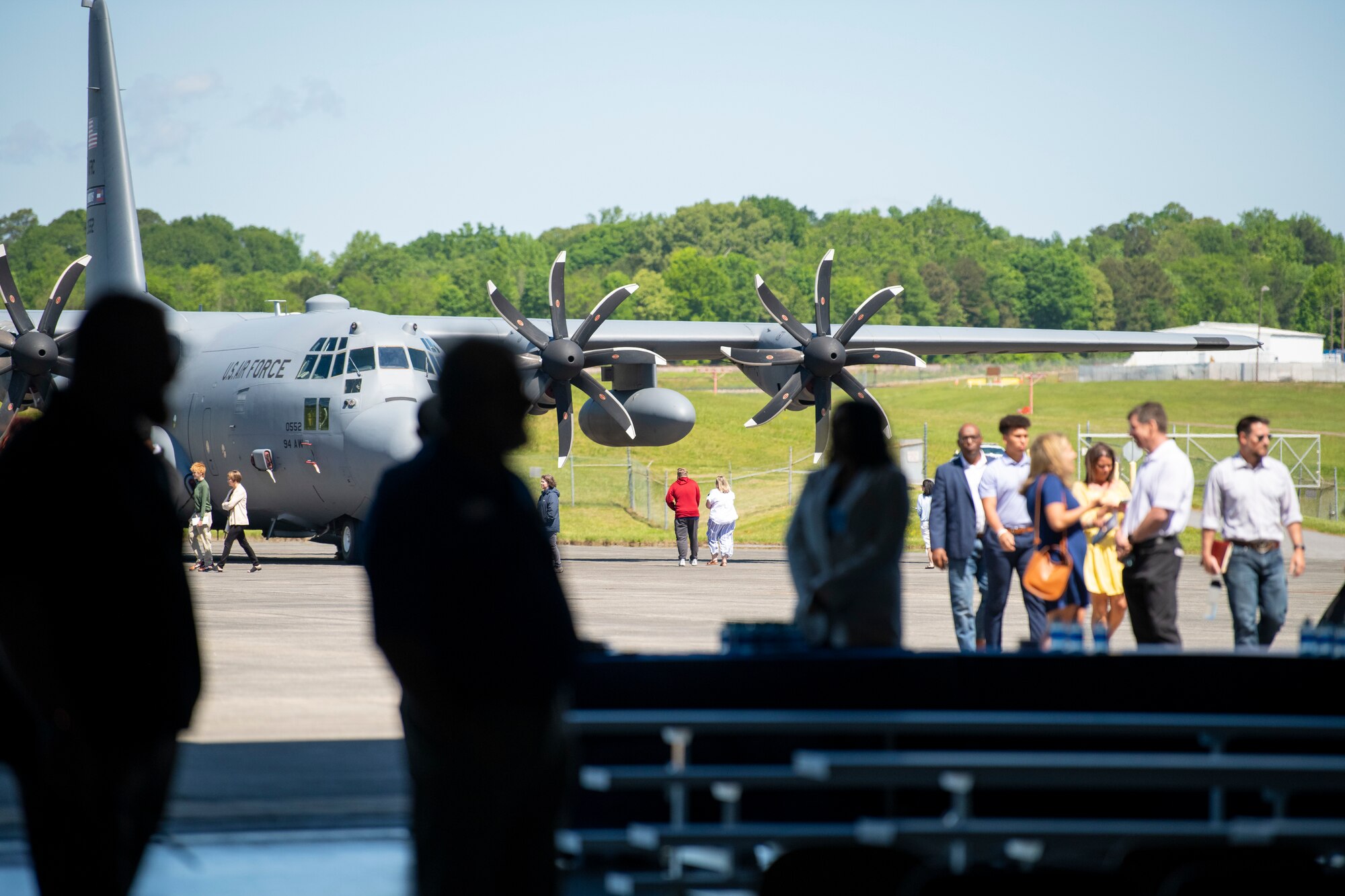 people stand outside in front of an aircraft