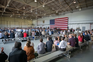 a crowd of people look on as people speak during an event