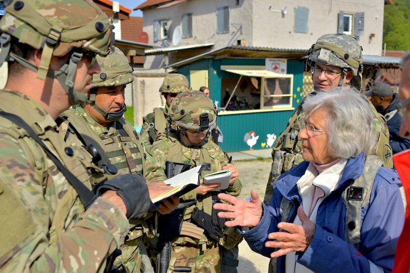 Soldiers with C Co/418th Civil Affairs Battalion, and the 1st Civil-Military Cooperation (CIMIC), Romanian Land Forces, conduct a mock community engagement with role players during Exercise Combined Resolve 18 here on May 5, 2023. Combined Resolve 18 allows exercise participants the opportunity to train alongside Allied and partner nations in a dynamic and realistic training environment provided by the Joint Multinational Readiness Center (JMRC).