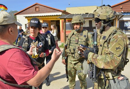 Spc. Tony Kosgei, a civil affairs specialist with C Co/418th Civil Affairs Battalion and Master Sgt. Marius Tudorache, a Civil-Military Cooperation (CIMIC) non-commissioned officer with the 1st CIMIC, Romanian Land Forces, conducted a key leader engagement with role players during Exercise Combined Resolve 18 here on May 4, 2023. Combined Resolve 18 breaks through all barriers of systems, processes, and human and linguistic boundaries allowing partners and allies to conduct operations as one team.