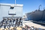 Ships moored at Naval Base San Diego are tied into shore power via cables and mounds on the pier.