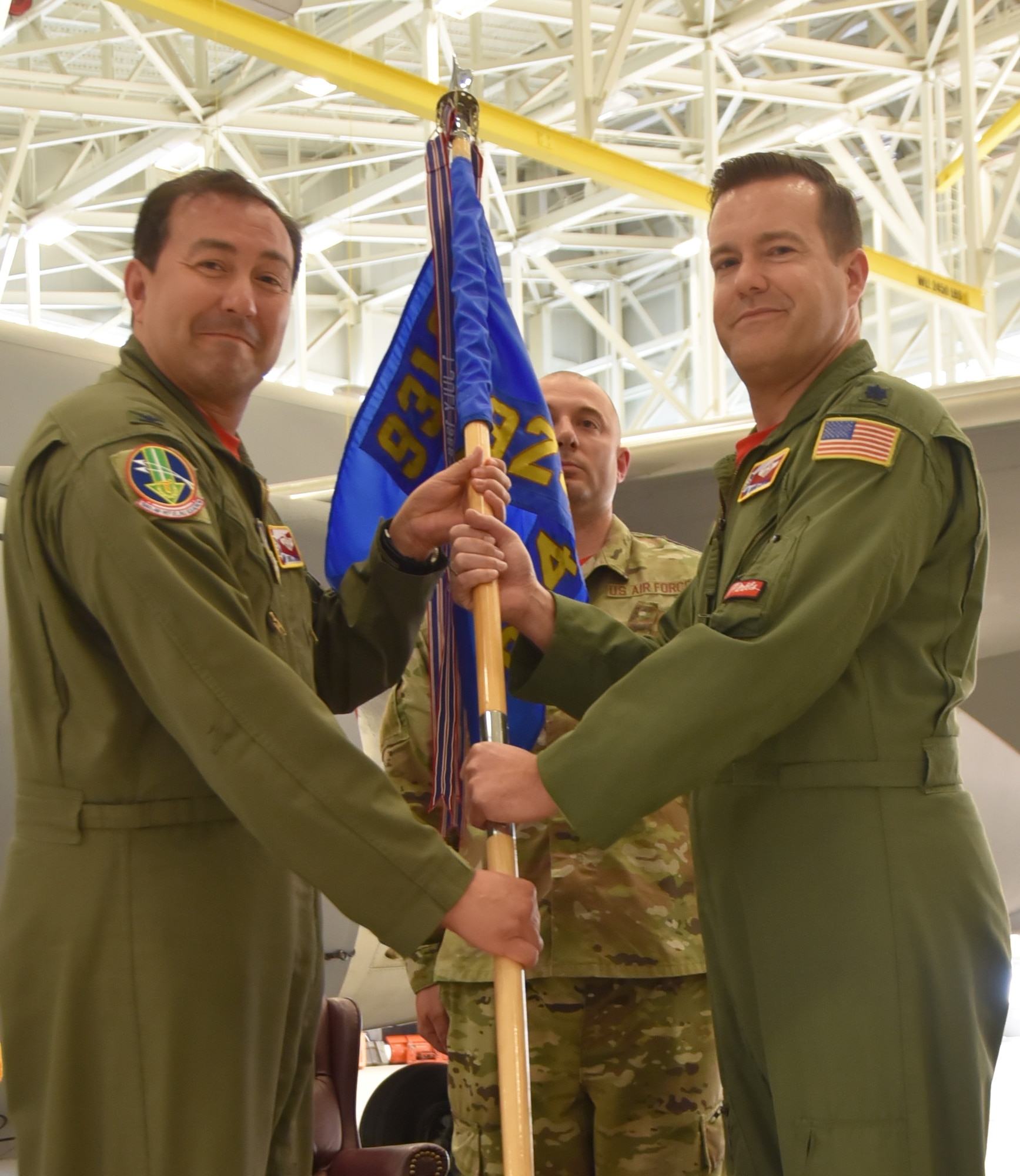 (Left to right) Col. Eric Rivero, 931st Operations Group commander, hands the guidon to Lt. Col. Brian Correll during an official change of command ceremony.