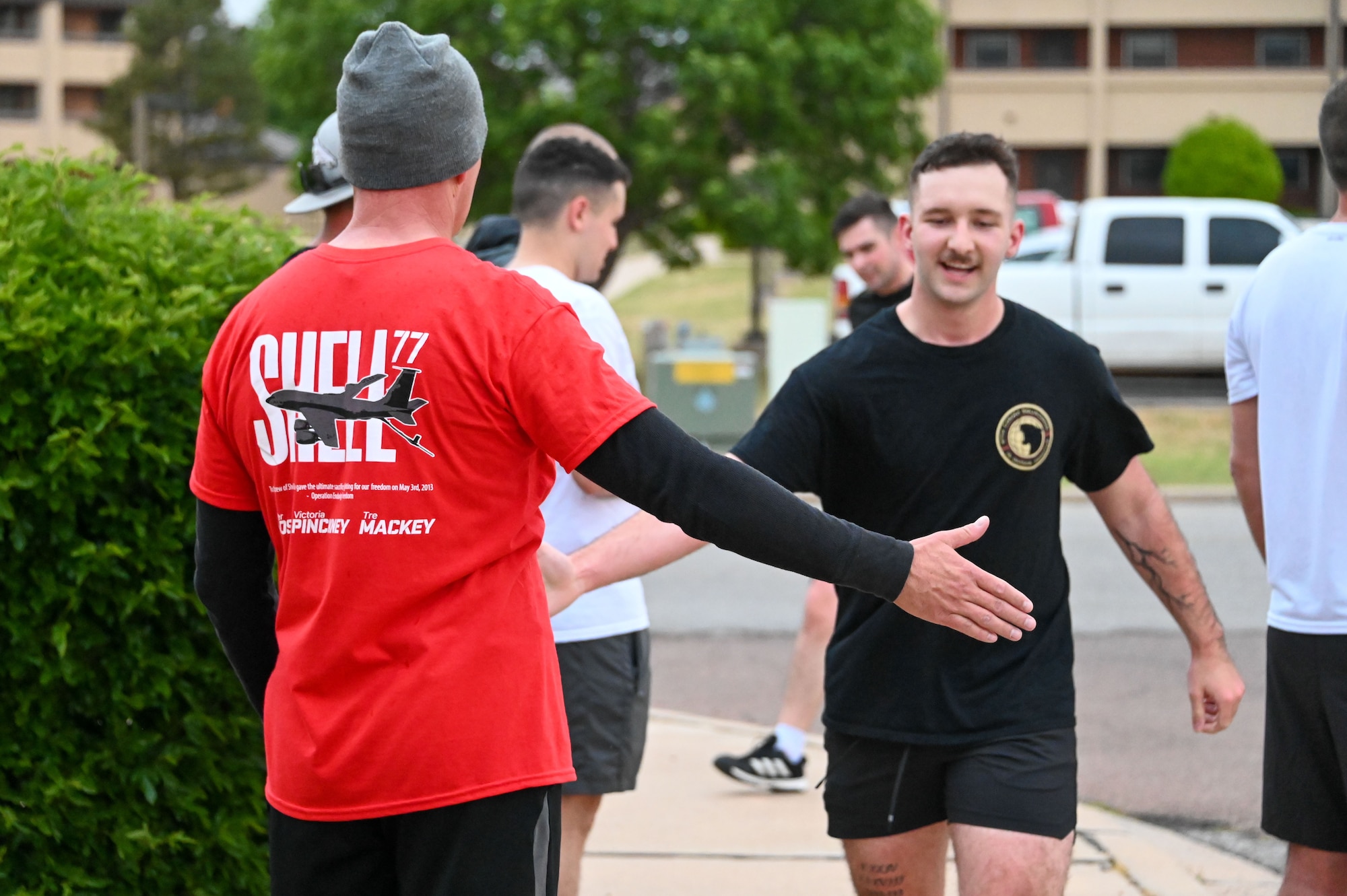 U.S. Air Force Col. Blaine Baker (left), 97th Air Mobility Wing commander, high-fives Airman 1st Class Christopher Chamberlain, 97th Communications Squadron cybersecurity Airman, after running in the Shell 77 Memorial 5k at Altus Air Force Base, Oklahoma, May 3, 2023. Airmen designed the 5k run to honor the fallen Airmen of the Shell 77 crash that occurred 10 years ago. (U.S. Air Force photo by Senior Airman Kayla Christenson)