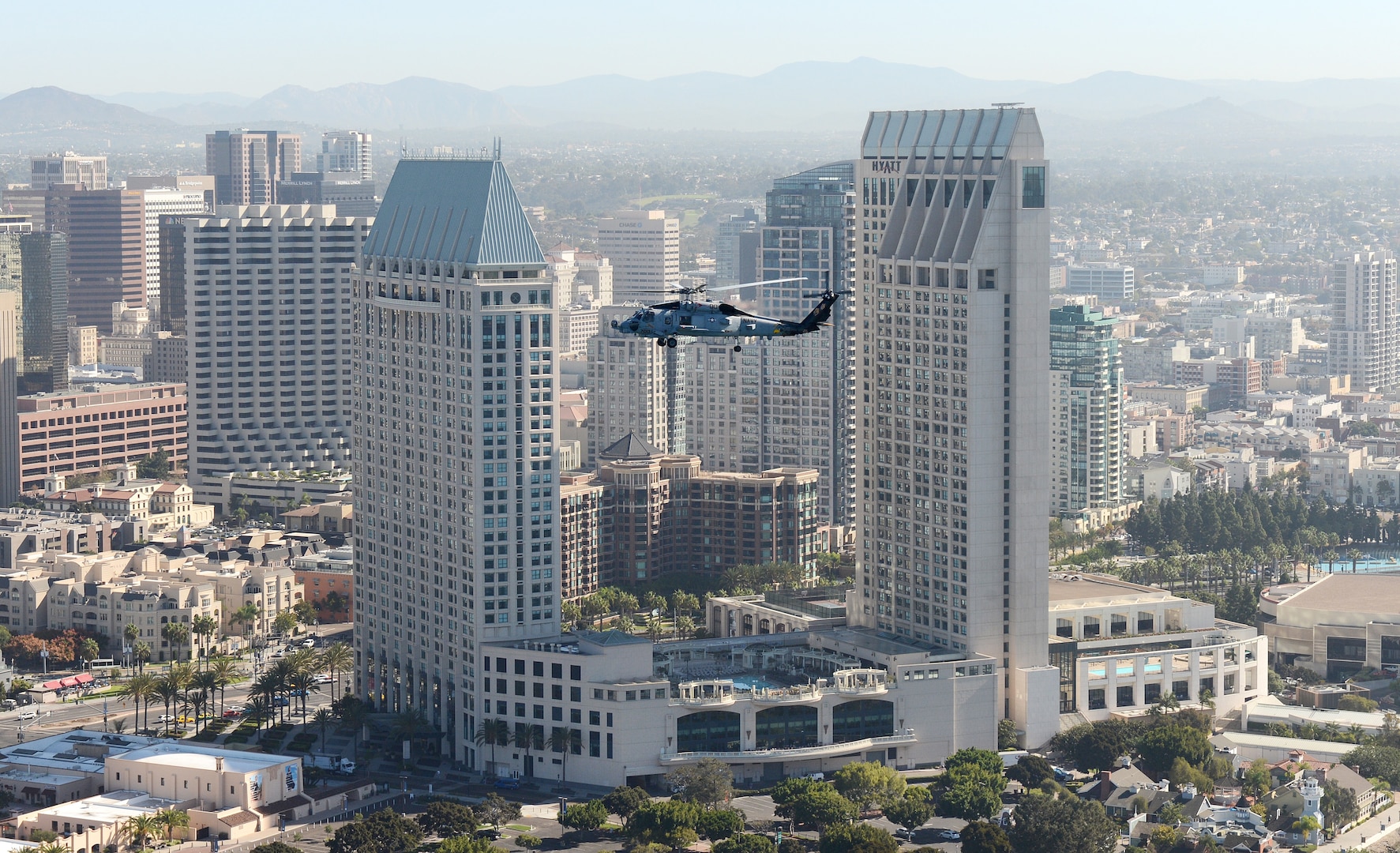 A chopper flies above the San Diego skyline.
