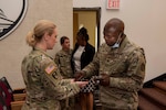 Capt. Christopher Anumata, from Ibo, Nigeria, a Roman Catholic chaplain at Walter Reed National Military Medical Center, blesses the hands of Col. Wendy Woodall, deputy director of Nursing, during a Blessing of the Hands ceremony in Memorial Auditorium at Walter Reed in Bethesda, Maryland, May 8, 2023. This event was held as a part of Walter Reed's celebration of National Nurses Week.