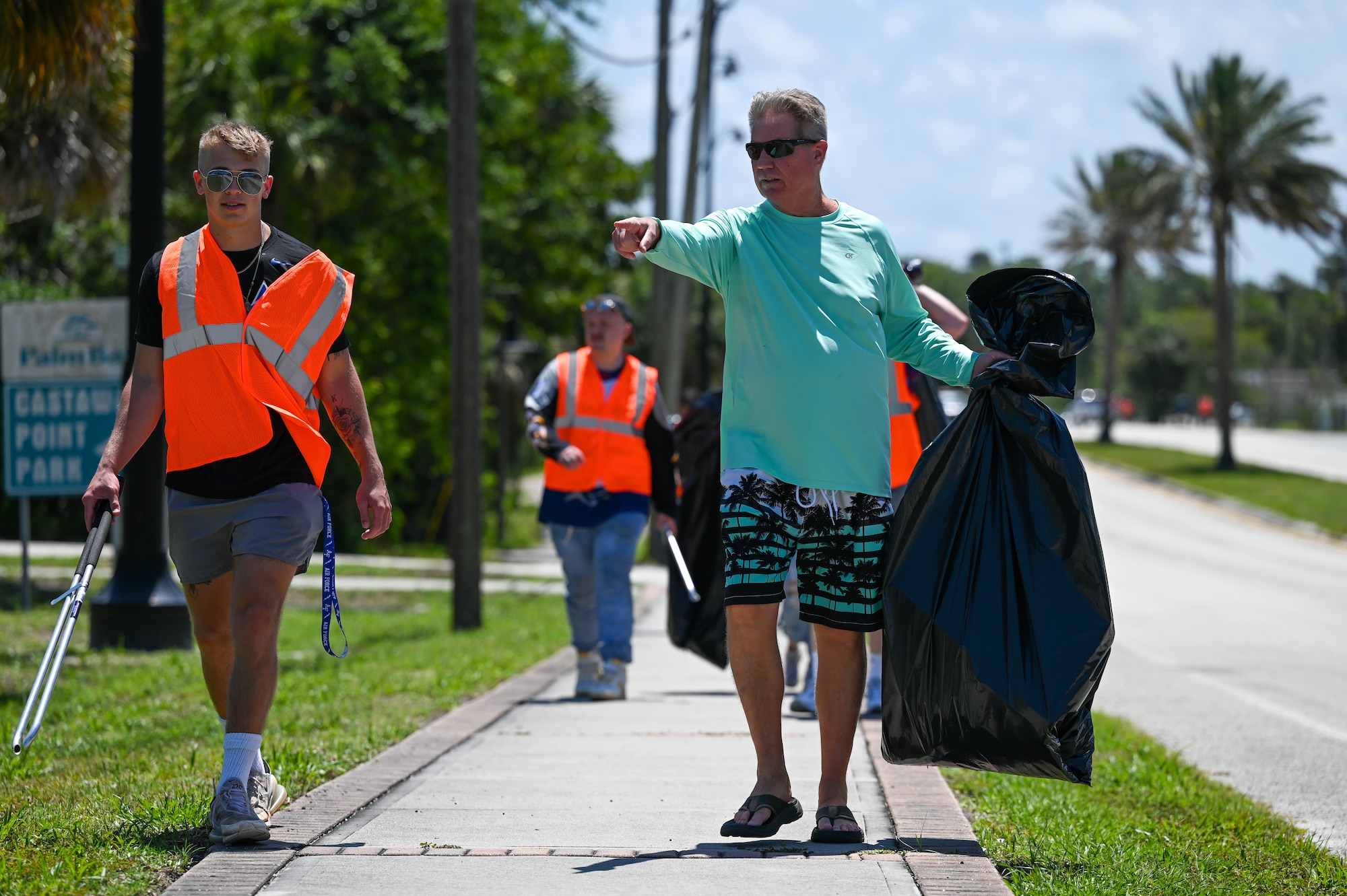 Members from 45th LRS clean a section of highway adopted in honor of Staff Sgt. Andrew Holman, 45th LRS air traffic controller on April 21, 2023 in Melbourne, Fla., Memorial Markers are signs posted at sites of incidents to remind others to drive safely. (U.S. Space Force photo by Senior Airman Samuel Becker)