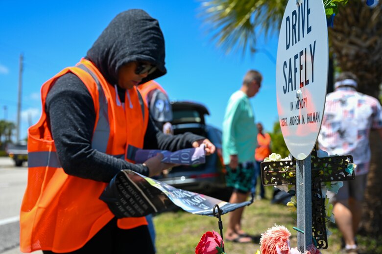 U.S. Air Force Master Sgt. Precious Smith, 45th LRS airfield manager hangs a new flag on Staff Sgt. Andrew Holman 45th LRS air traffic controllers memorial sign April 21, 2023 in Melbourne, Fla. 45th LRS adopted the section of highway that Staff Sgt. Andrew Holman 45th LRS air traffic controller had passed away on. (U.S. Space Force photo by Senior Airman Samuel Becker)