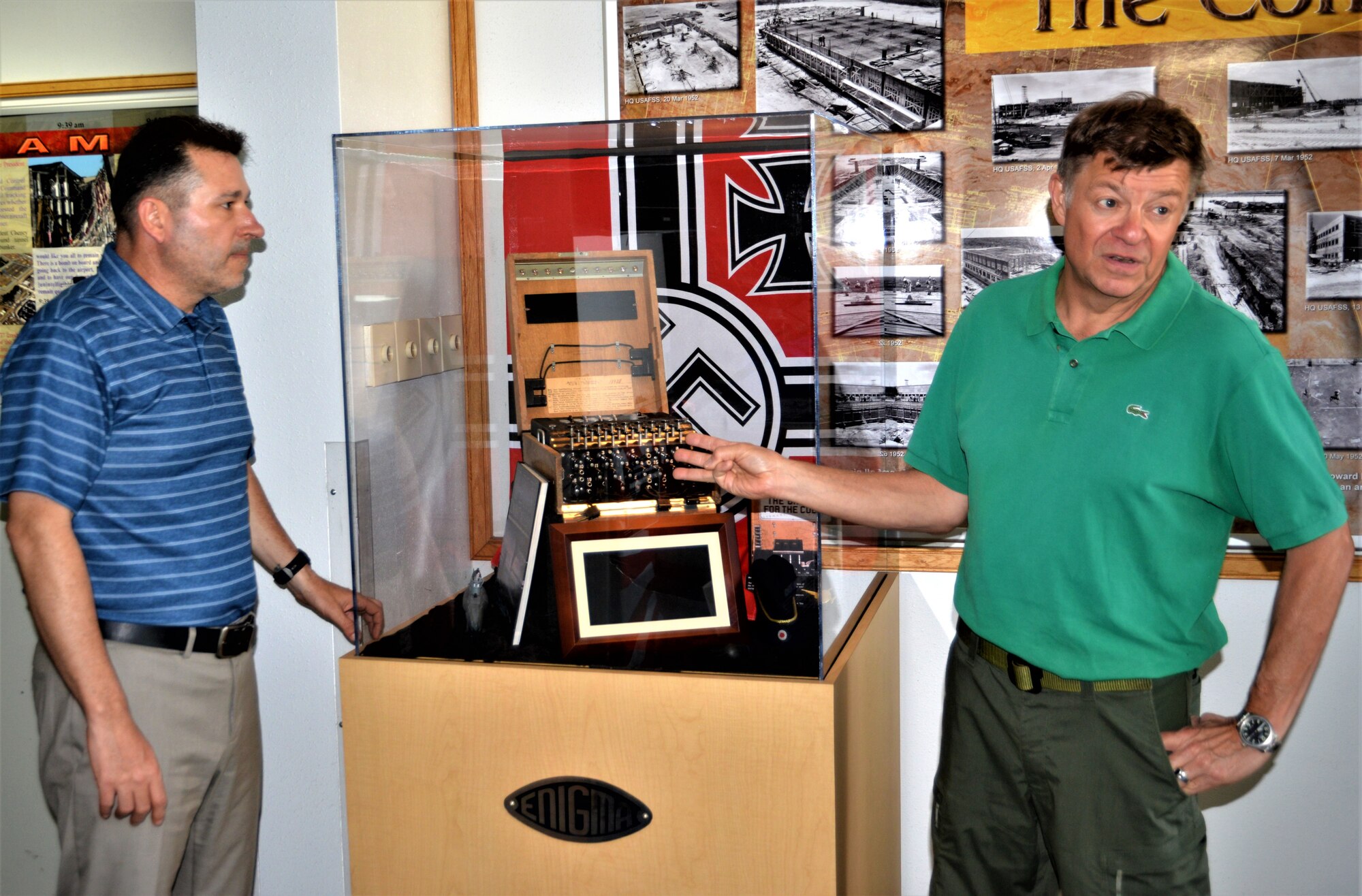 A photo of people next to a encoder machine.