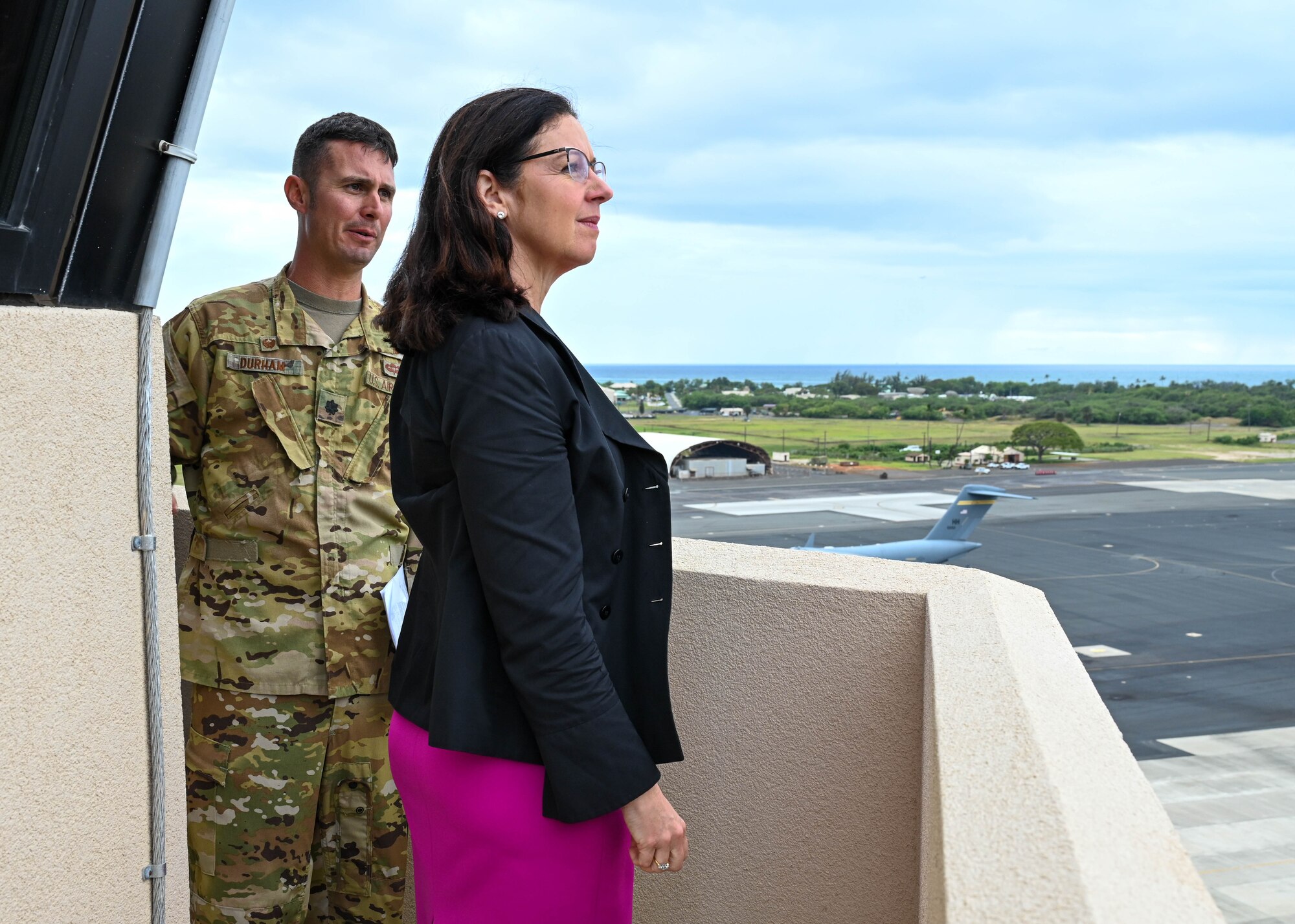 Lt. Col. Scott Durham, 15th Operational Support Squadron commander, briefs Kristyn Jones, assistant secretary of the Air Force for Financial Management and Comptroller, performing the duties of under secretary of the Air Force, on the catwalk of the Air Traffic Control Tower at Joint Base Pearl Harbor-Hickam, Hawaii, May 2, 2023. Durham shared statistics regarding the health of the Hickam Field runway and expressed thoughts on the way ahead for repairs and sustainment of the pavement. (U.S. Air Force photo by Senior Airman Zoie Cox)