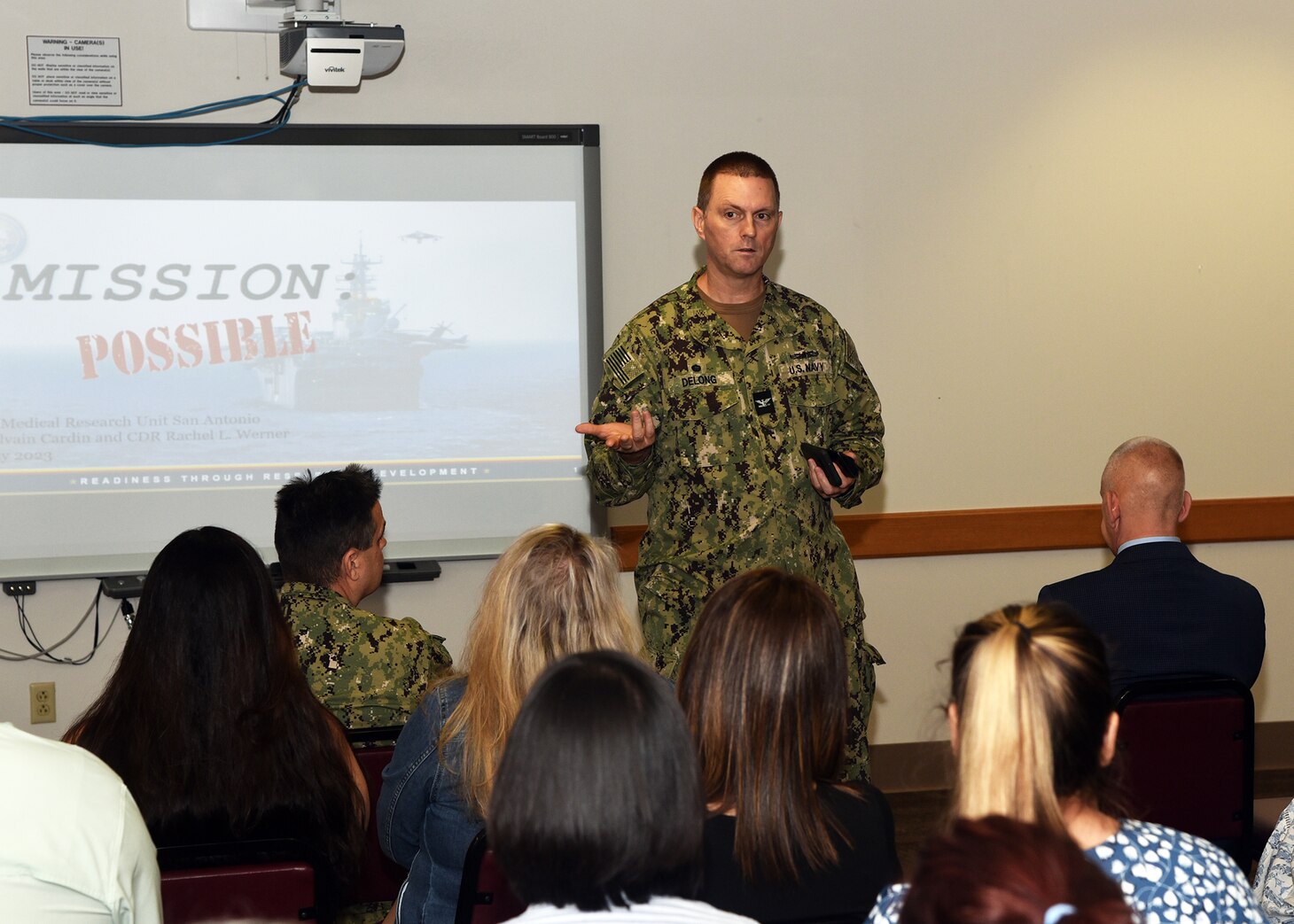 JOINT BASE SAN ANTONIO-FORT SAM HOUSTON – (May 3, 2023) – Commanding Officer Capt. Gerald DeLong of Naval Medical Research Unit (NAMRU) San Antonio speaks to personnel during the fifth edition of “Mission Possible,” an information-sharing event held at the Battlefield Health and Trauma (BHT) Research Institute. The purpose of “Mission Possible” is to better inform members of the command on the tactics, techniques, and procedures of the three science directorates to include the resource acquisitions and administrative directorates. NAMRU San Antonio’s mission is to conduct gap driven combat casualty care, craniofacial, and directed energy research to improve survival, operational readiness, and safety of Department of Defense personnel engaged in routine and expeditionary operations. It is one of the leading research and development laboratories for the U.S. Navy under the DoD and is one of eight subordinate research commands in the global network of laboratories operating under the Naval Medical Research Command in Silver Spring, Md. (U.S. Navy photo by Burrell Parmer, NAMRU San Antonio Public Affairs/Released)