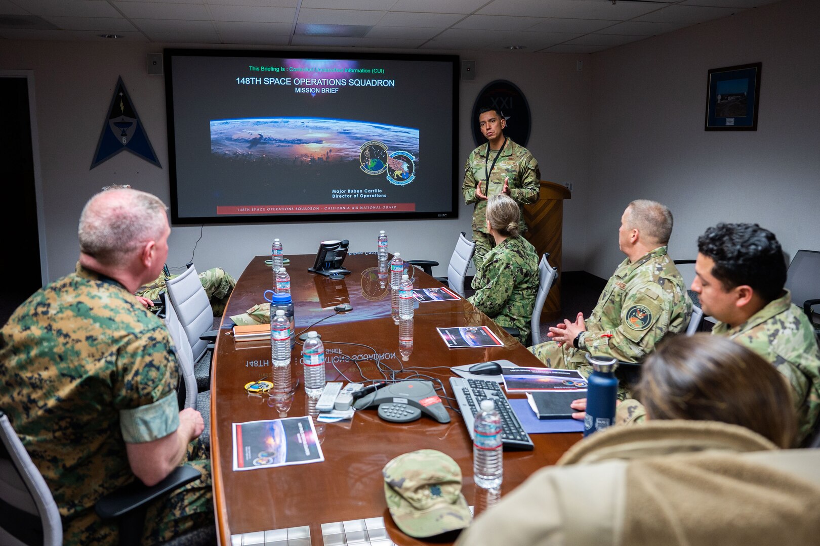 U.S. Marine Corps Master Gunnery Sgt. Scott H. Stalker, U.S. Space Command (USPACECOM) command senior enlisted leader, left, listens to a 148th Space Operations Squadron mission brief from U.S. Air Force Maj. Ruben Carrillo, 148 SOPS director of operations, at the Vandenberg Tracking Station on Vandenberg Space Force Base, Calif., May 6, 2023. The 148 SOPS is an Air National Guard satellite control unit which operates the Air Force’s MILSATCOM systems providing the warfighter with communication capabilities. In time of emergency, by order of the Governor of California, the 148 SOPS can also provide military support to civil authorities to the California Joint Force Headquarters Operations Center (Command and Control) and Joint Incident Site Communications Capability for cyberspace. (U.S. Space Force photo by Tech. Sgt. Luke Kitterman)