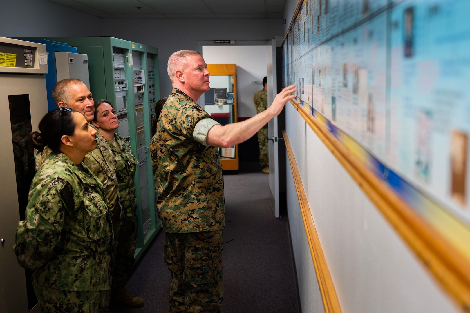 U.S. Marine Corps Master Gunnery Sgt. Scott H. Stalker, U.S. Space Command (USPACECOM) command senior enlisted leader, middle, and other USSPACECOM members look at a timeline of newsworthy events pertaining to the 148th Space Operations Squadron (148 SOPS) at the Vandenberg Tracking Station on Vandenberg Space Force Base, Calif., May 6, 2023. The 148 SOPS is an Air National Guard satellite control unit which operates the Air Force’s MILSATCOM systems providing the warfighter with communication capabilities. In time of emergency, by order of the Governor of California, the 148 SOPS can also provide military support to civil authorities to the California Joint Force Headquarters Operations Center (Command and Control) and Joint Incident Site Communications Capability for cyberspace. (U.S. Space Force photo by Tech. Sgt. Luke Kitterman)