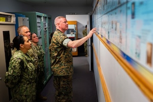 U.S. Marine Corps Master Gunnery Sgt. Scott H. Stalker, U.S. Space Command (USPACECOM) command senior enlisted leader, middle, and other USSPACECOM members look at a timeline of newsworthy events pertaining to the 148th Space Operations Squadron (148 SOPS) at the Vandenberg Tracking Station on Vandenberg Space Force Base, Calif., May 6, 2023. The 148 SOPS is an Air National Guard satellite control unit which operates the Air Force’s MILSATCOM systems providing the warfighter with communication capabilities. In time of emergency, by order of the Governor of California, the 148 SOPS can also provide military support to civil authorities to the California Joint Force Headquarters Operations Center (Command and Control) and Joint Incident Site Communications Capability for cyberspace. (U.S. Space Force photo by Tech. Sgt. Luke Kitterman)