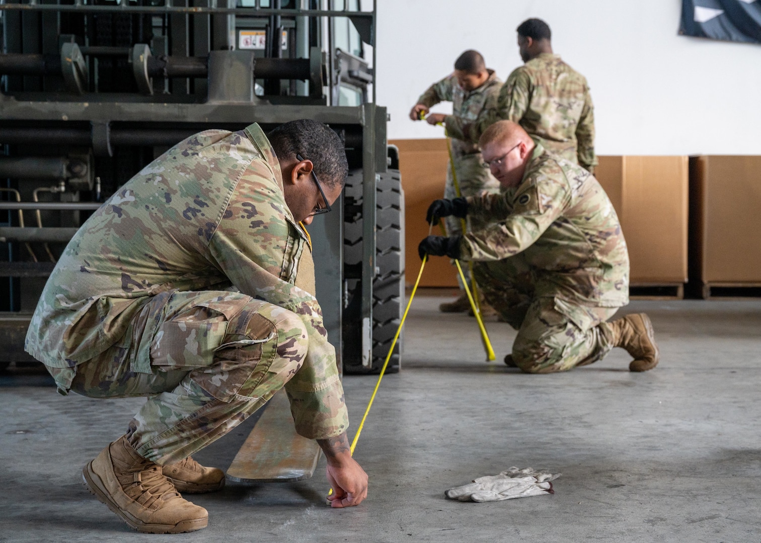Service Members measure a forklift.