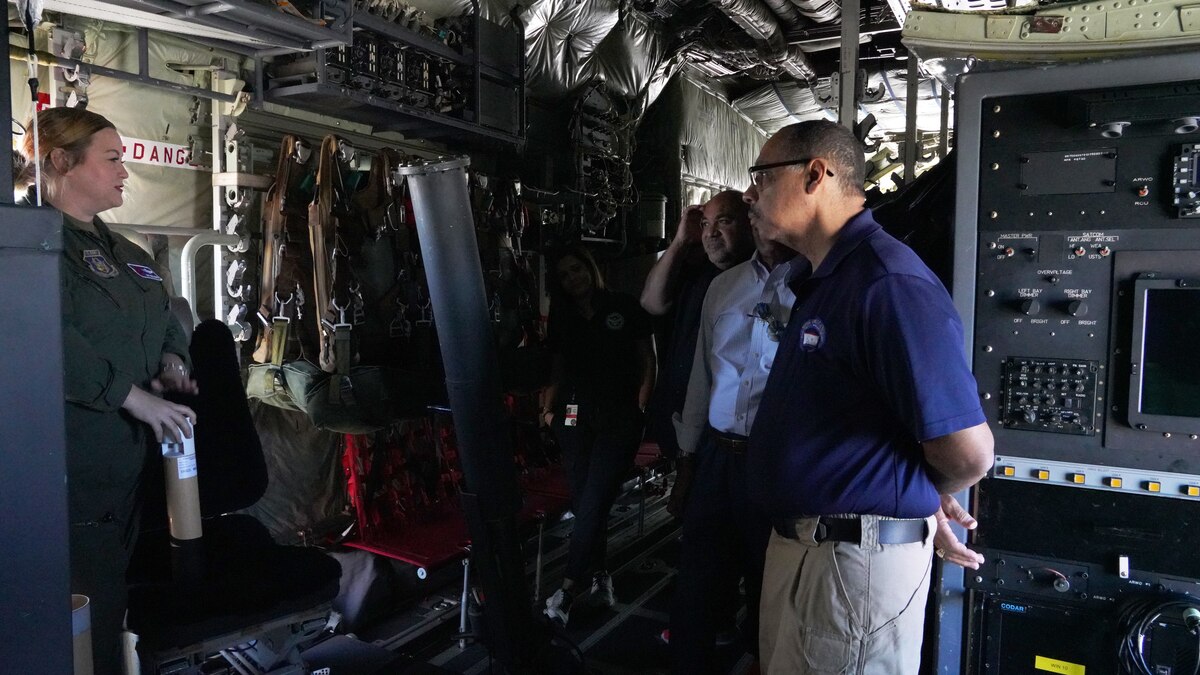 Master Sgt. Jenna Hemphill explains the dropsonde she is holding and her job to a group of people touring the WC-130J Super Hercules.