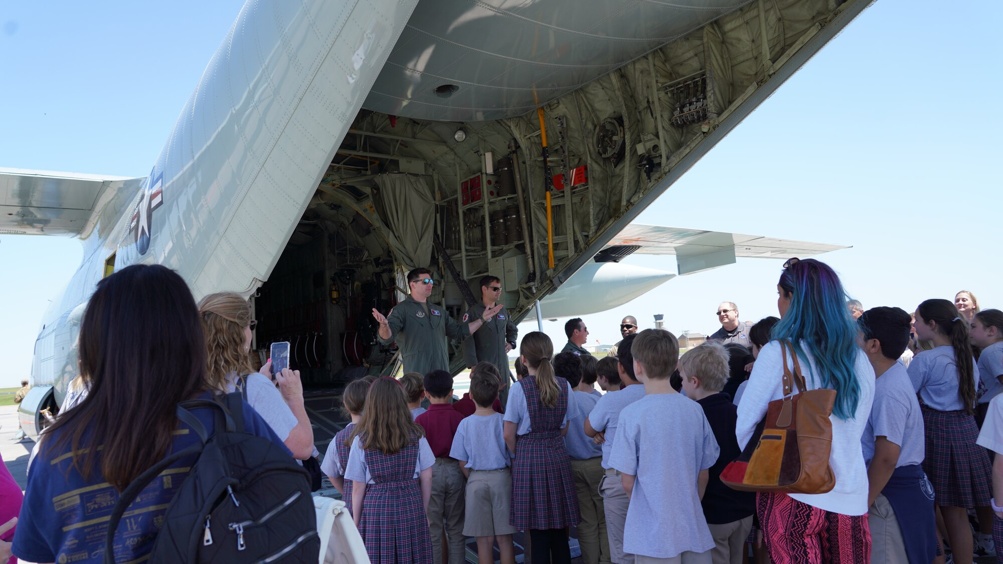 A group of students stand behind a WC-130J Super Hercules listening to a military members explain the Hurricane Hunting mission.
