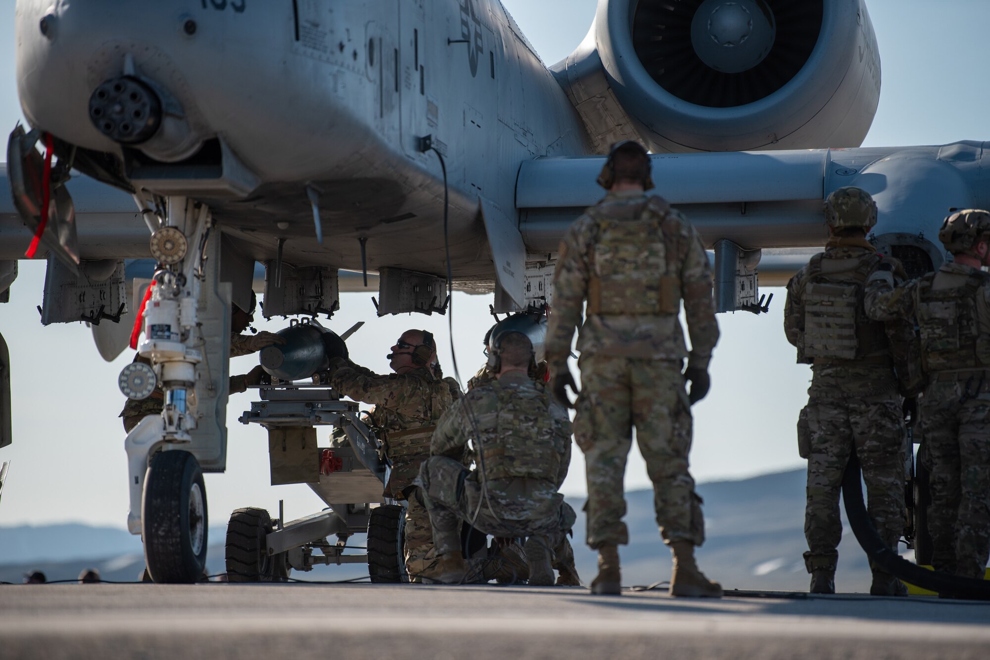 Airmen with the 127th Fighter Wing conduct an Integrated Combat Turn weapons reload on one of their A-10 Thunderbolt IIs on Highway 287 in Wyoming during Exercise Agile Chariot, April 30, 2023, honing capabilities linked to Agile Combat Employment. Instead of relying on large, fixed bases and infrastructure, ACE employs smaller, more dispersed locations and teams to rapidly move aircraft, pilots and other personnel as needed. Under ACE, millions of miles of public roads can serve as functional runways with Forward Arming and Refueling Points when necessary. (U.S. Air National Guard photo by Master Sgt. Phil Speck)