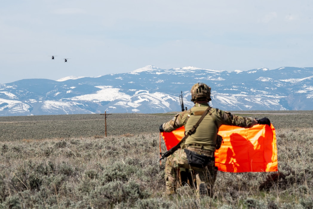 An Airman from the Kentucky Air National Guard’s 123rd Special Tactics Squadron holds an indicator panel to designate a landing zone for a pair of MH-6M Little Birds from the 160th Special Operations Aviation Regiment during Exercise Agile Chariot near Riverton, Wyoming, May 2, 2023. Agile Chariot tested Agile Combat Employment capabilities, including using smaller, more dispersed locations and teams to rapidly move and support aircraft, pilots and other personnel wherever they’re needed. (U.S. Air National Guard photo by Master Sgt. Phil Speck)