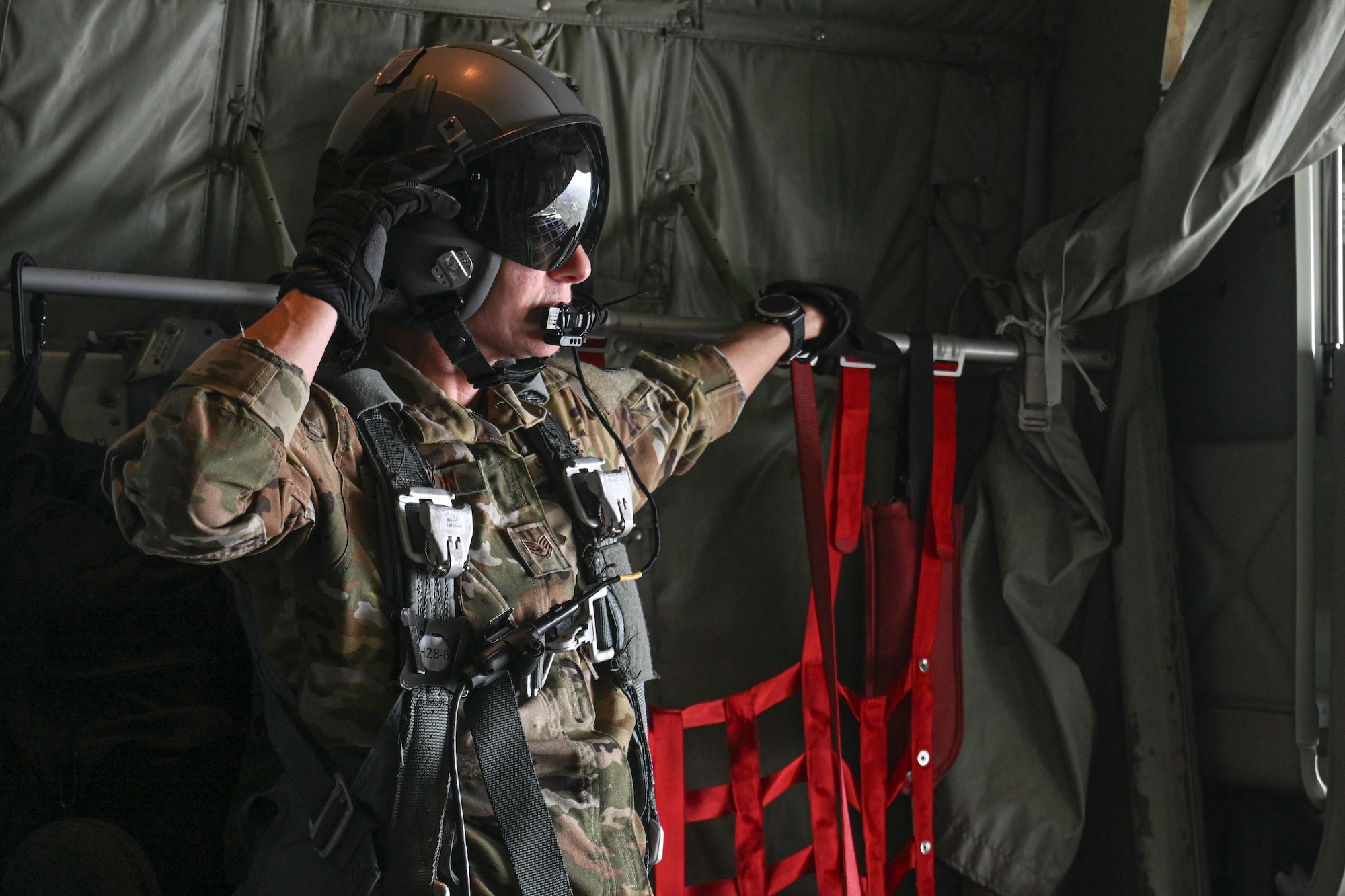 Airmen parachute jump out of the back of a C-130J Super Hercules