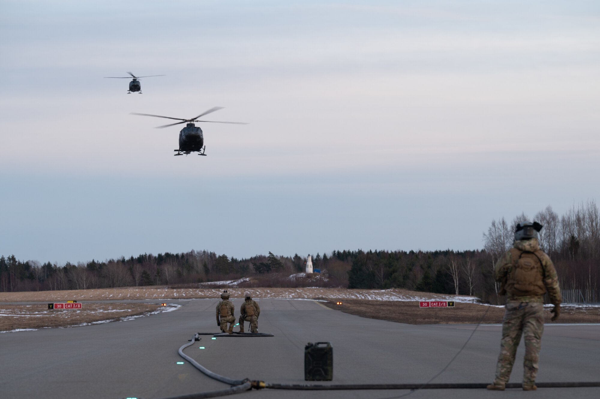 U.S. Air Force Forward Area Refueling Point (FARP) specialists assigned to the 100th Air Refueling Wing, prepare for the landing of two Royal Norwegian Air Force Bell 412SP helicopters, Norway, March 10, 2023.