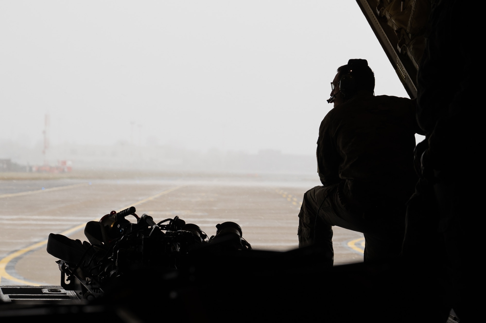 A U.S. Air Force loadmaster assigned to the 352nd Special Operations Wing, surveys conditions from a MC-130J Commando II aircraft taxiing on the flight line, United Kingdom, March 10, 2023.