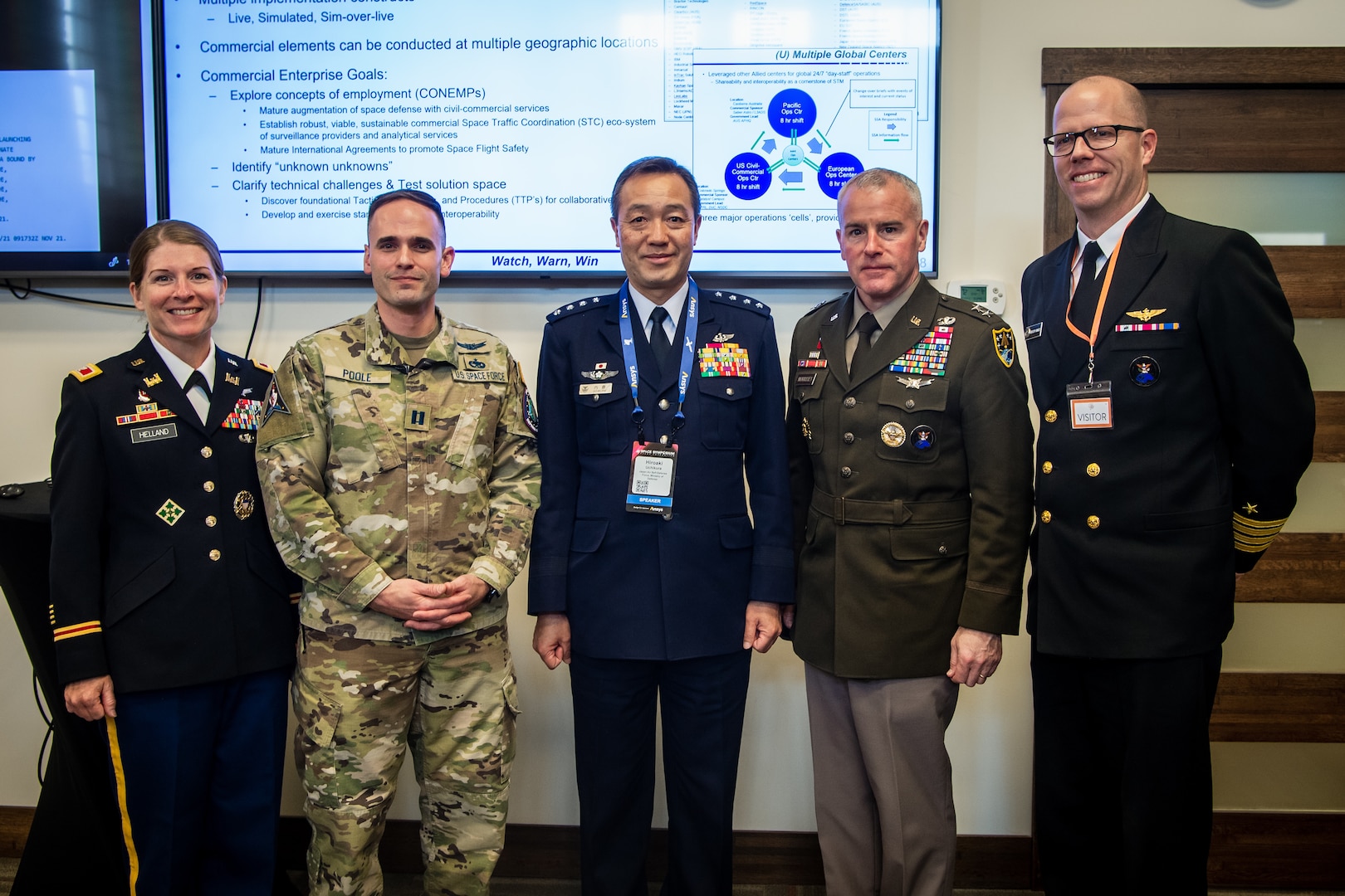 Five military officials in uniform pose for a group photo