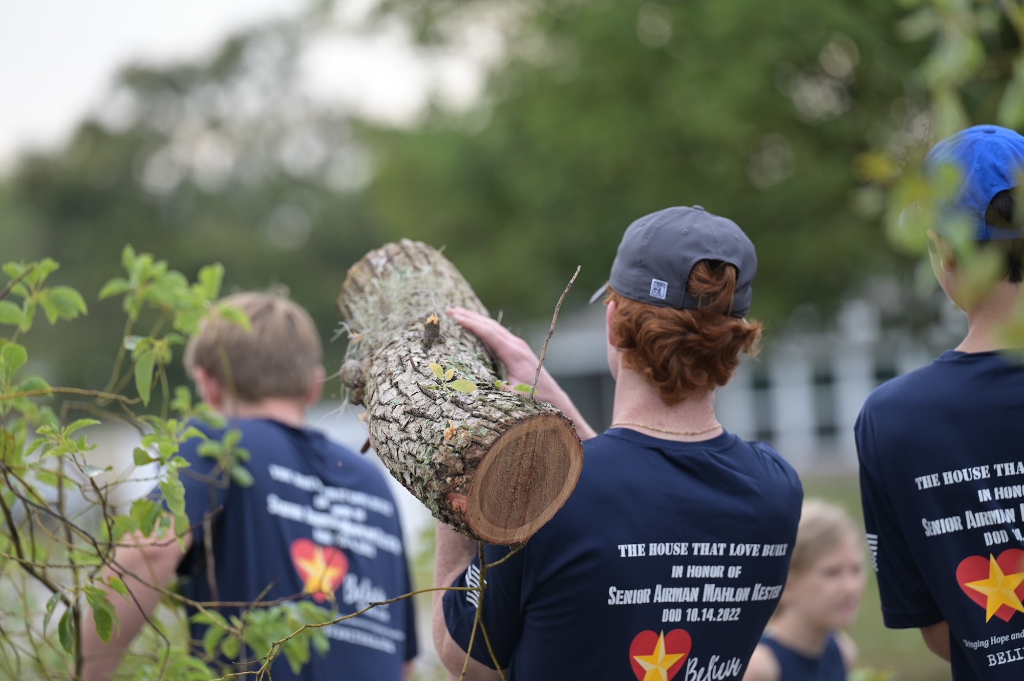 Volunteers carry logs.