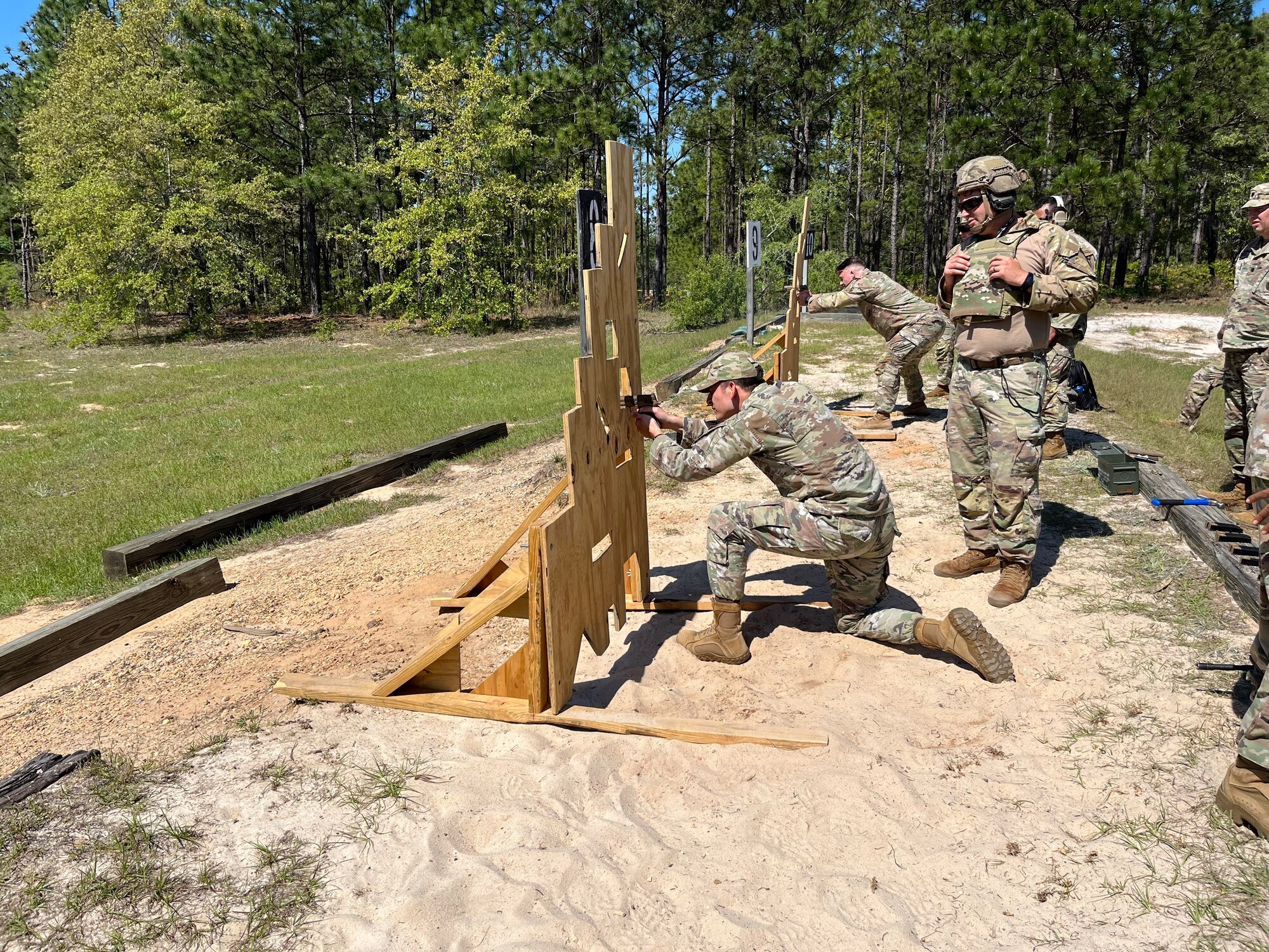 U.S. Air Force Capt. James Hejna, bottom middle, the 571st Mobility Support Advisory Squadron readiness flight commander, fires a SIG Sauer M-18 pistol while a U.S. Army Soldier with the 1st Security Force Assistance Brigade supervises the firing range at Fort Benning, Georgia, April 19, 2023.
