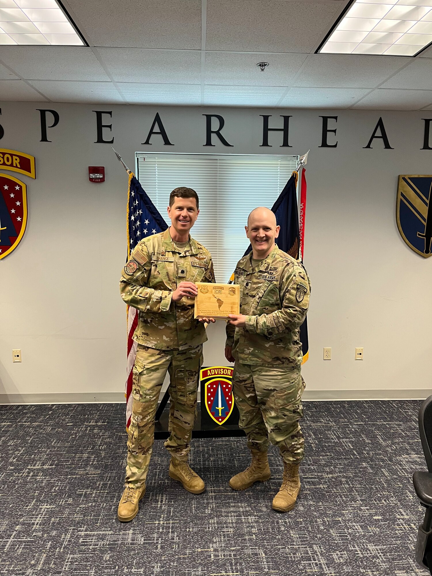 U.S. Air Force Lt. Col. Robert Chance, left, 571st Mobility Support Advisory Squadron commander, gives an appreciation gift to U.S. Army Lt. Col. James Gallagher, right, 1st Security Force Assistance Brigade executive officer, at Fort Benning, Georgia, April 20, 2023.