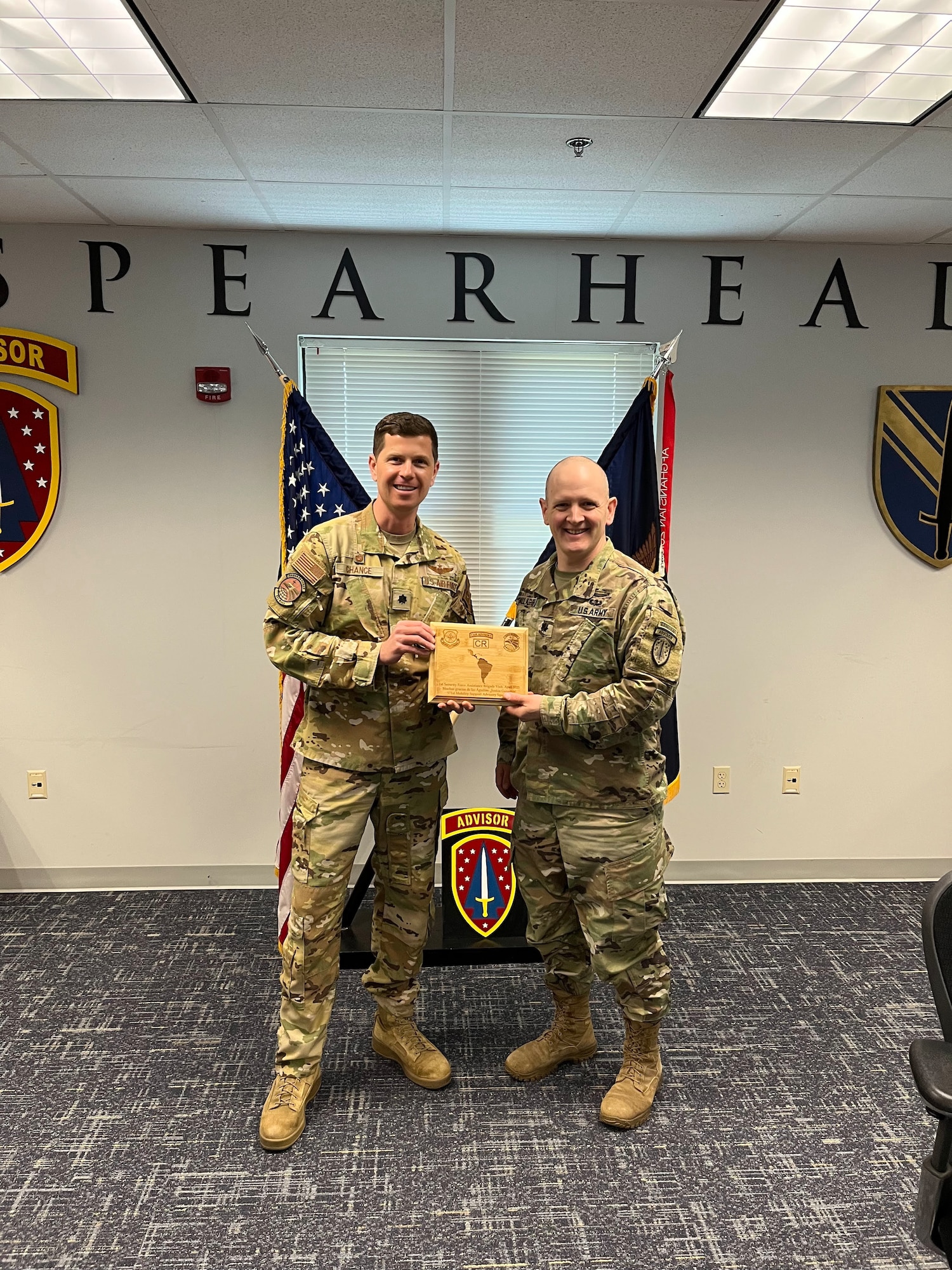 U.S. Air Force Lt. Col. Robert Chance, left, 571st Mobility Support Advisory Squadron commander, gives an appreciation gift to U.S. Army Lt. Col. James Gallagher, right, 1st Security Force Assistance Brigade executive officer, at Fort Benning, Georgia, April 20, 2023.