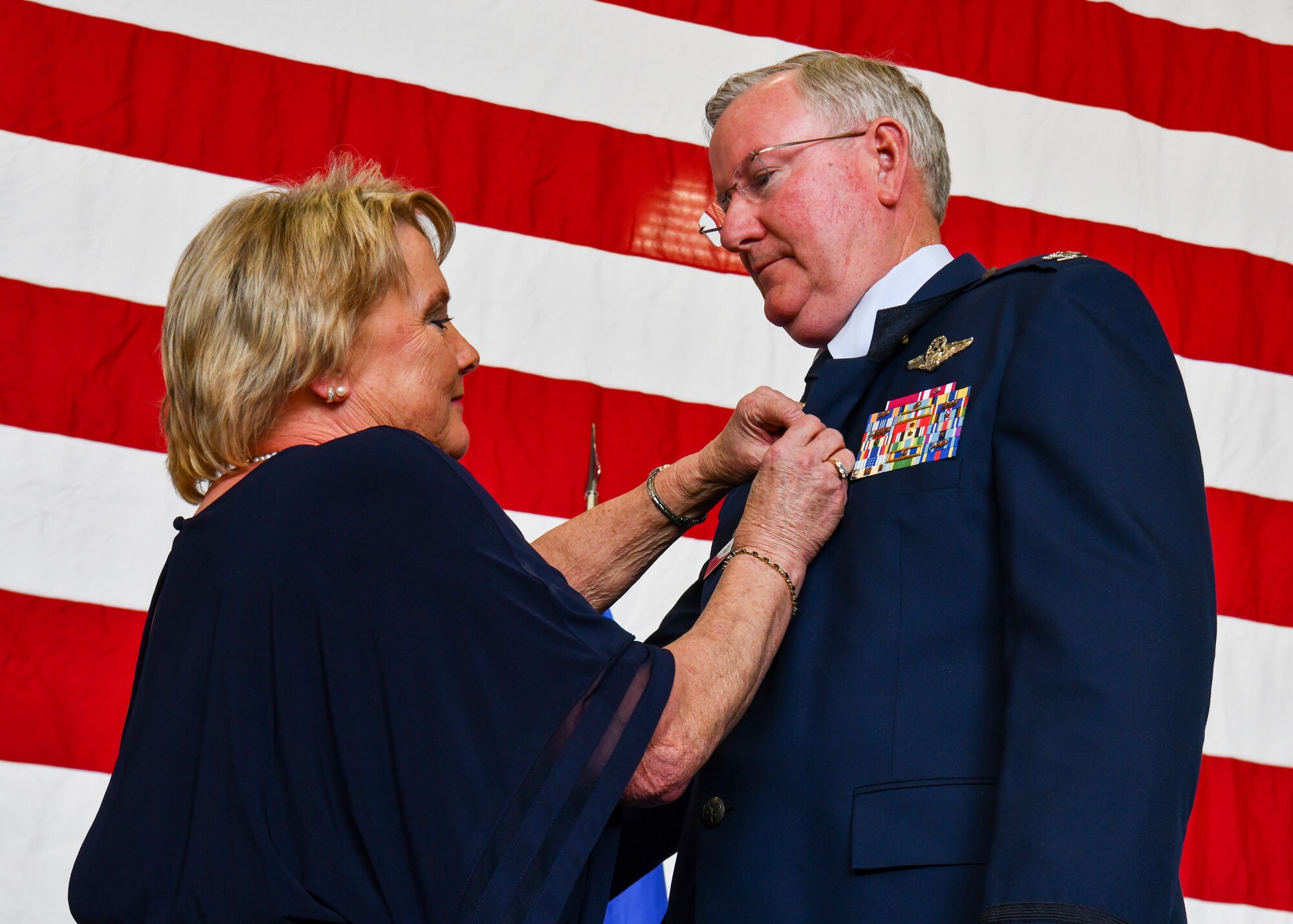 Mrs. Diana Van Dootingh holds the lapel of her husband Col. Jeff Van Dootingh, the commander of the 910th Airlift Wing, to place his official retirement pin, May 6, 2023, at Youngstown Air Reserve Station, Ohio.