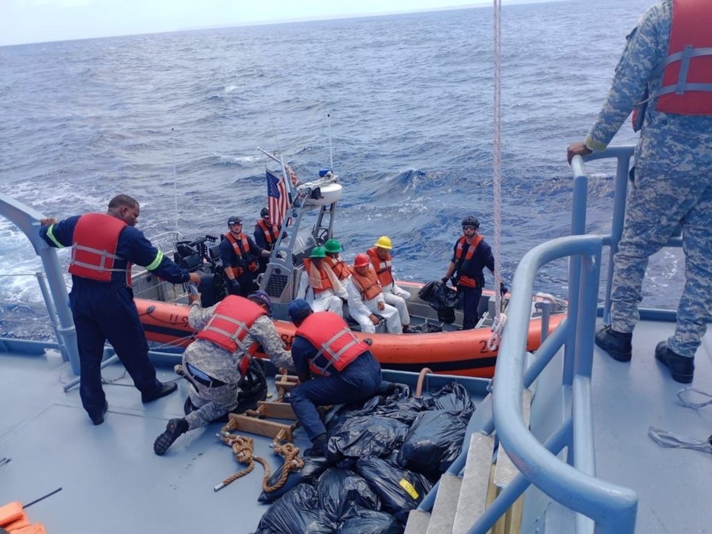 The Coast Guard Cutter Joseph Napier small boat crew returns 74 migrants to a Dominican Republic Navy vessel May 8, 2023.  The group was among 119 other migrants who were interdicted by the Coast Guard in five separate cases of unlawful irregular maritime migration in the Mona Passage between May 5 to May 8, 2023.  (Courtesy Photos)