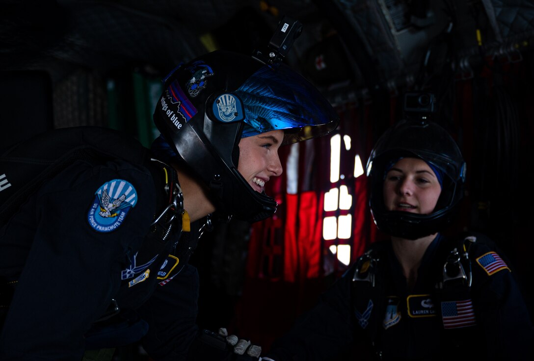 A parachute team member prepares to jump from a helicopter.