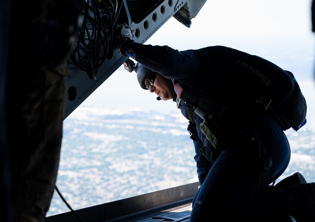 A parachute team member looks out of a helicopter.