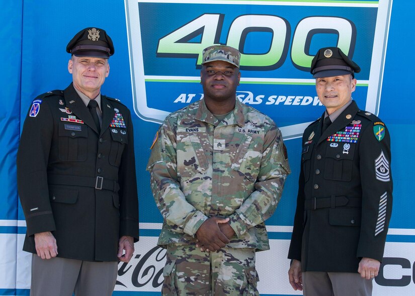 U.S. Army Brig. Gen. Dean Thompson, the commanding general of 353rd Civil Affairs Command (left), Sgt. Donovan Evans, a culinary specialist assigned to 511th Quartermaster Company, Special Troops Battalion, 1st Infantry Division Sustainment Brigade, 1st Inf. Div.(center), and Command Sgt. Maj. Clifford K. Lo, the command sergeant major of 353rd Civ. Aff. Cmd., gather for a photo at Kansas Speedway, Kansas City, Kan., May 7, 2023. Thompson and Lo held a reenlistment ceremony prior to the start of the AdventHealth 400 NASCAR race, where Soldiers from 1st Inf. Div. reenlisted in the middle of the speedway. (U.S. Army photo by Spc. Kenneth Barnet)