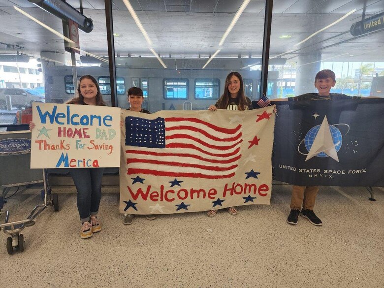 The children of Maj. Cameron Coon welcome home their dad following his six-and-a-half-month deployment to Qatar last month.